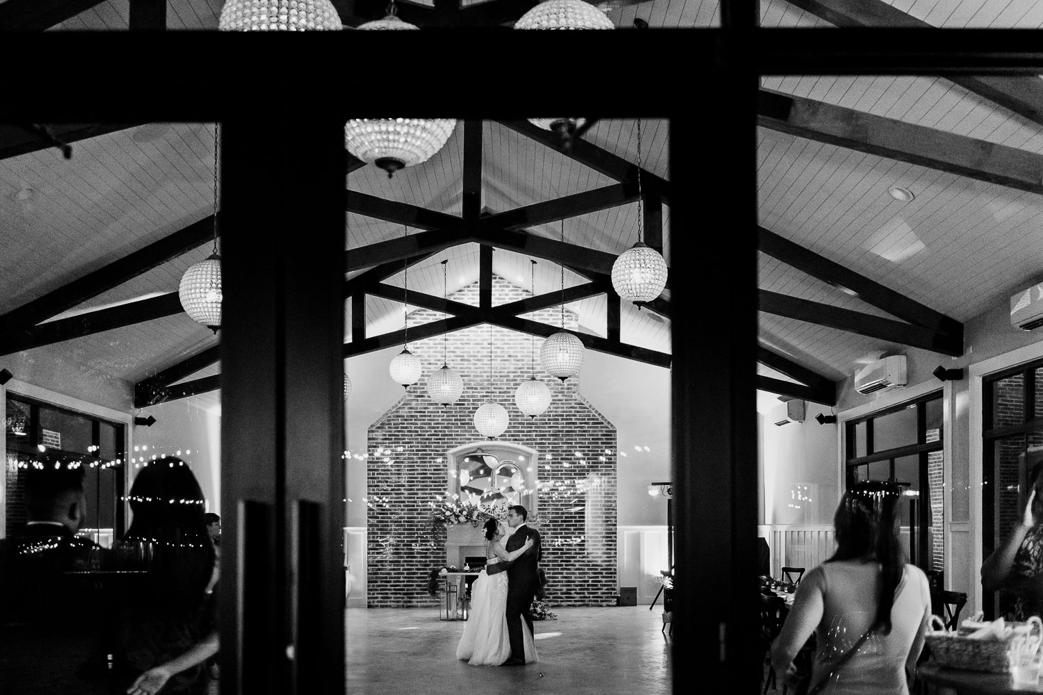 Couple dancing in elegant reception venue.
