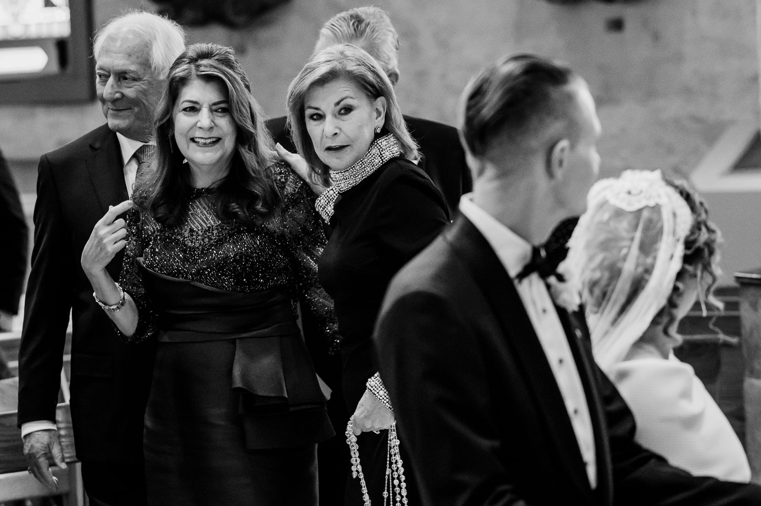 Wedding guests in formal attire gathering.