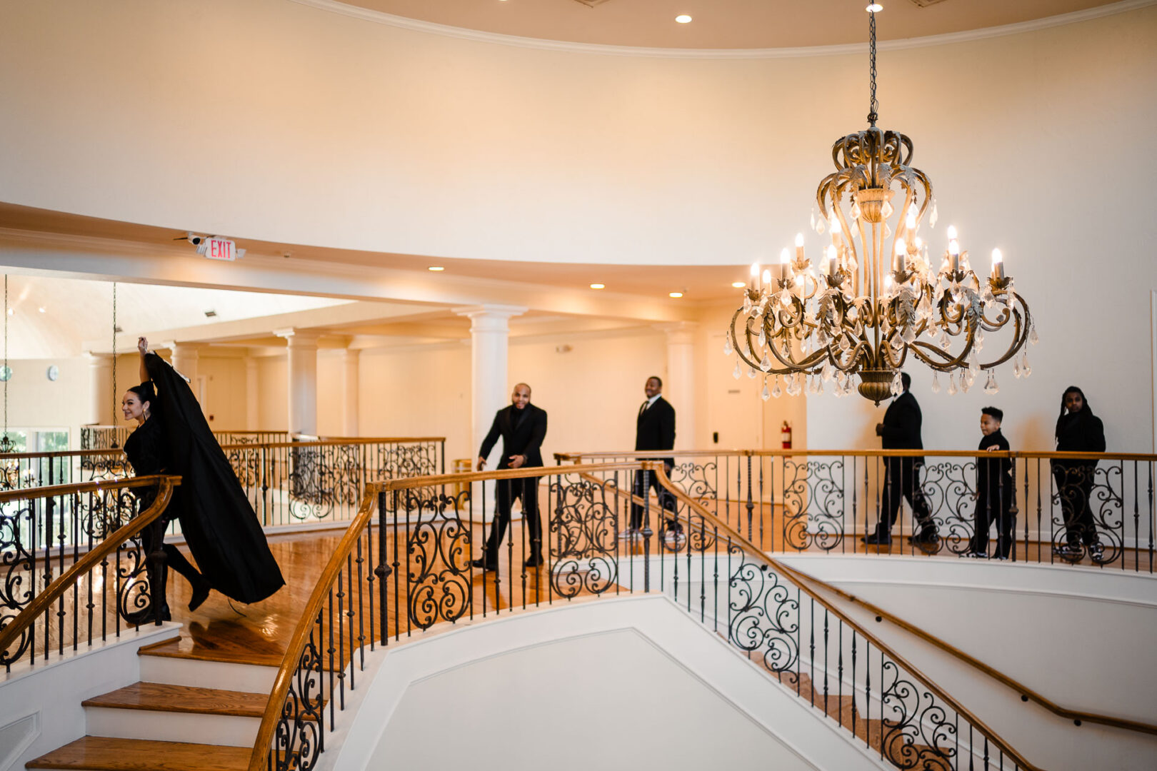 The Springs Weddings & Events | Candice + Larry 4 Elegant staircase with chandelier and guests.
