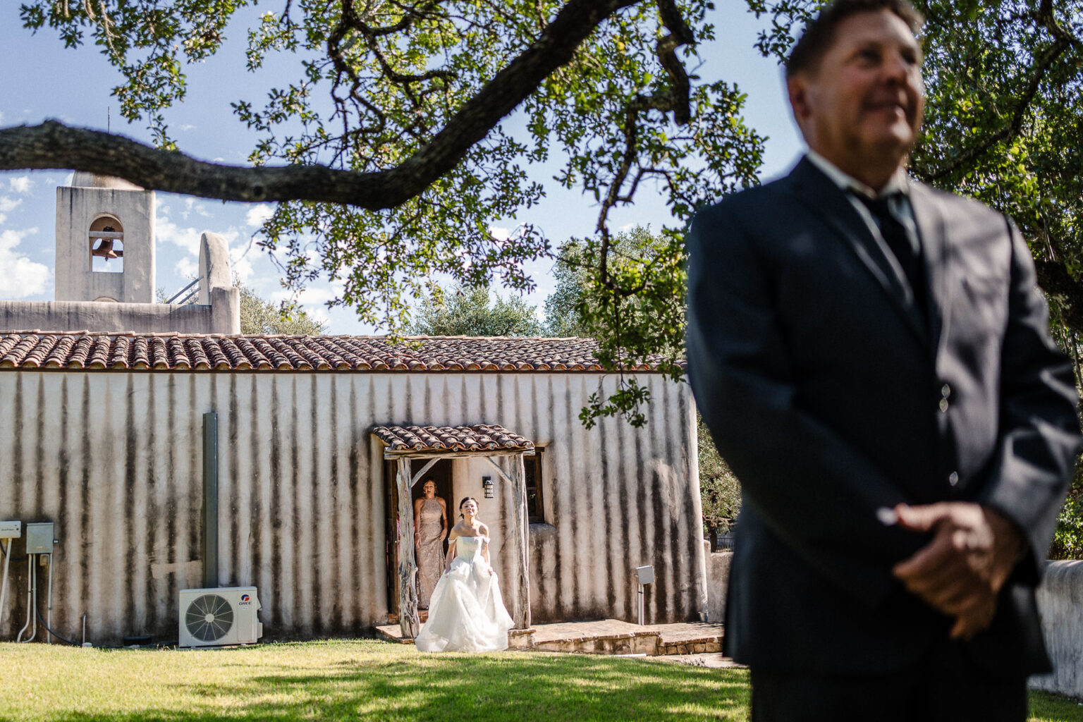 Bride entering chapel with groom nearby.