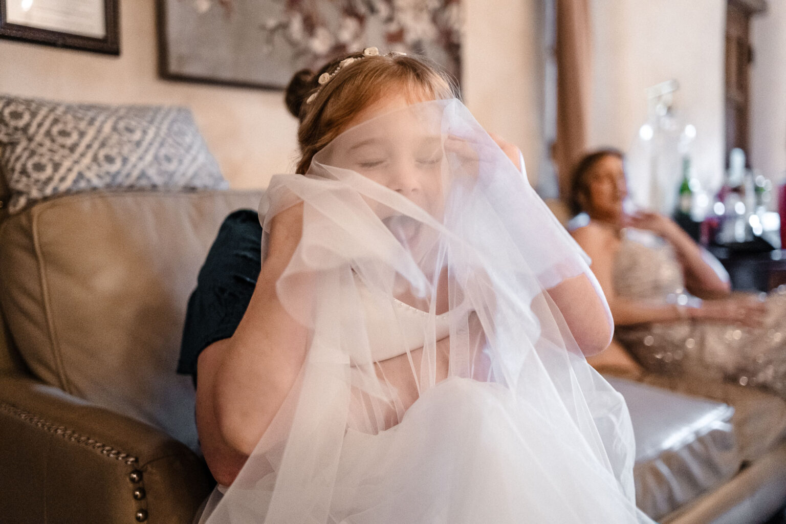 Bride preparing with veil and friends.