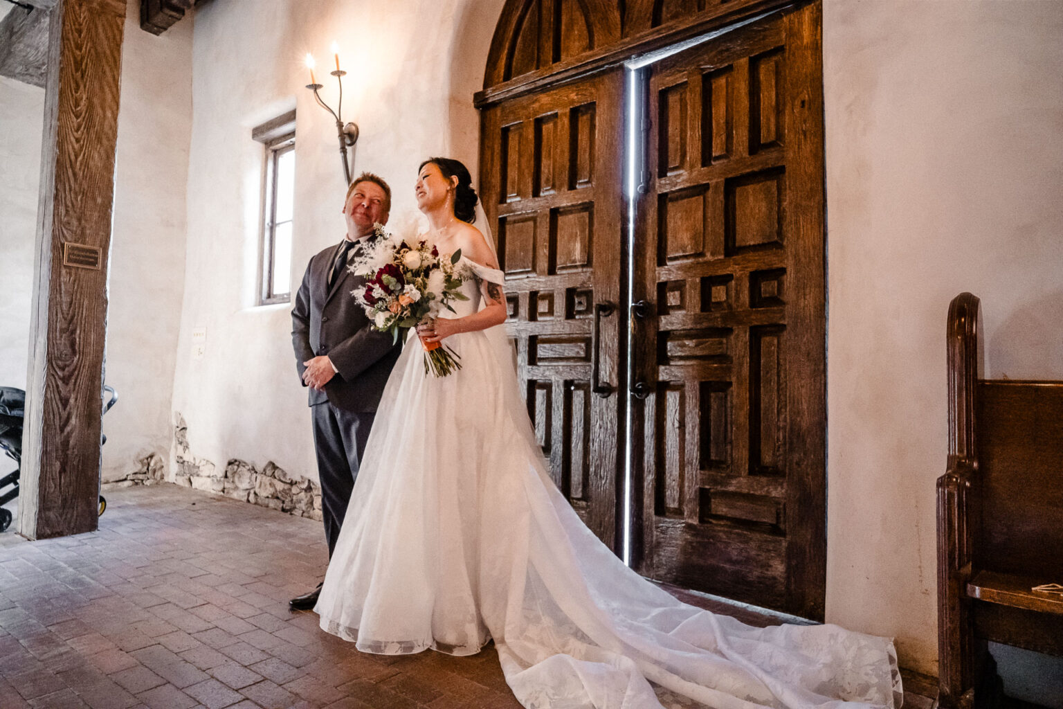 Bride and groom by wooden doors.