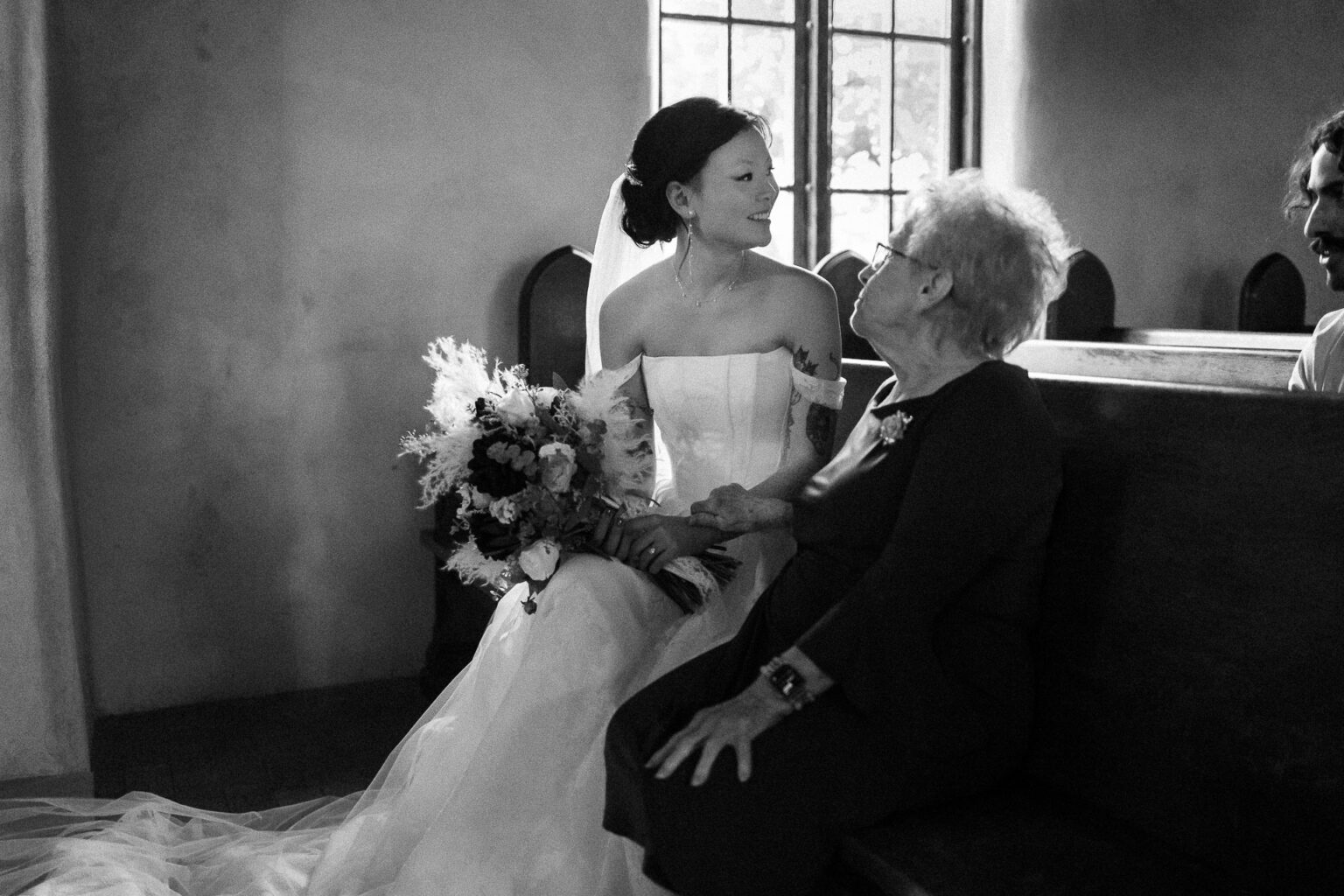 Bride sitting with elderly woman.