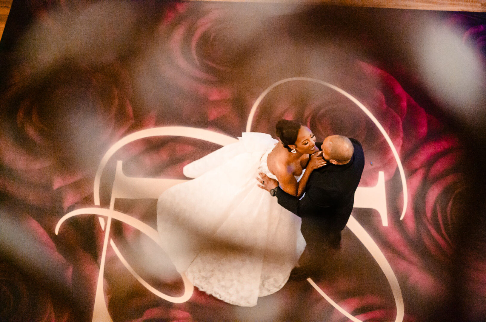 The Springs Weddings & Events | Candice + Larry 41 Larry and Candice dancing on floral patterned floor.