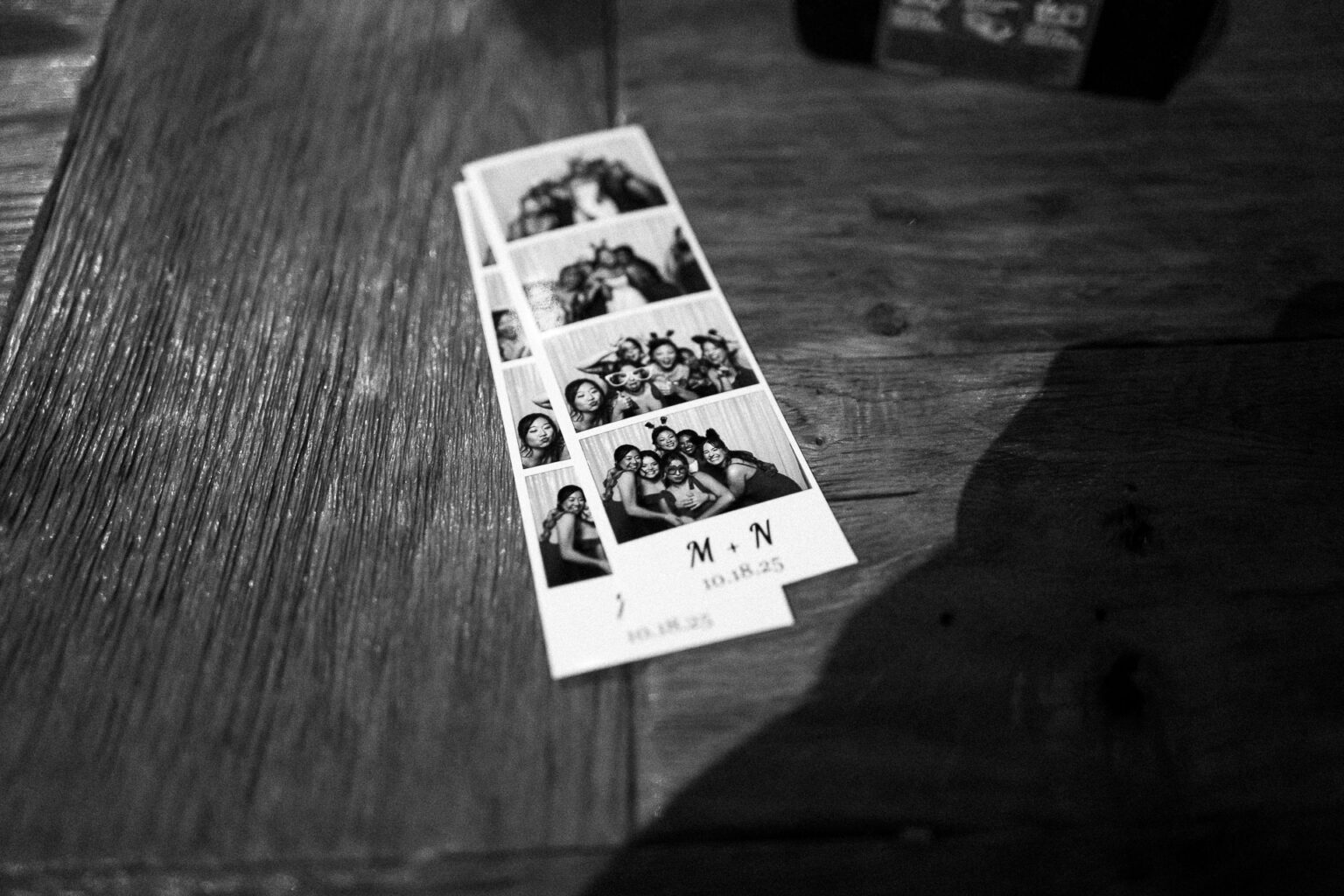 Photo booth strips on wooden table.