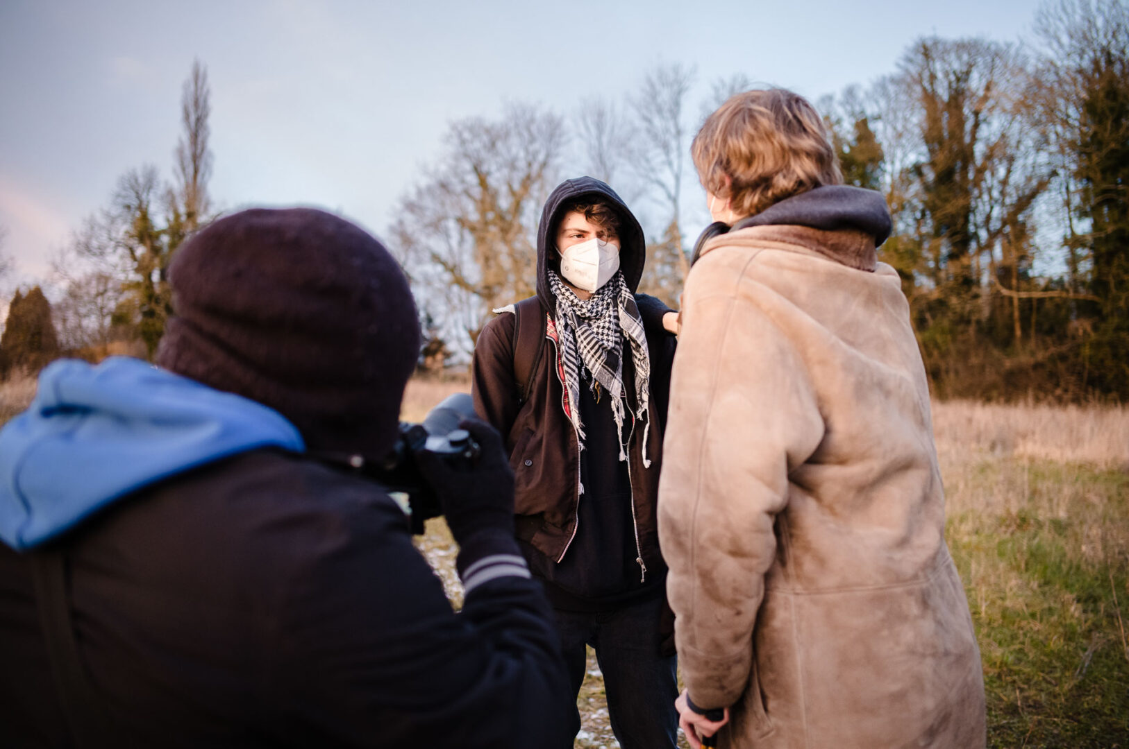 Documentary & Observational Still Photography 11 Crew members talk and coordinate while referencing pages on an outdoor set