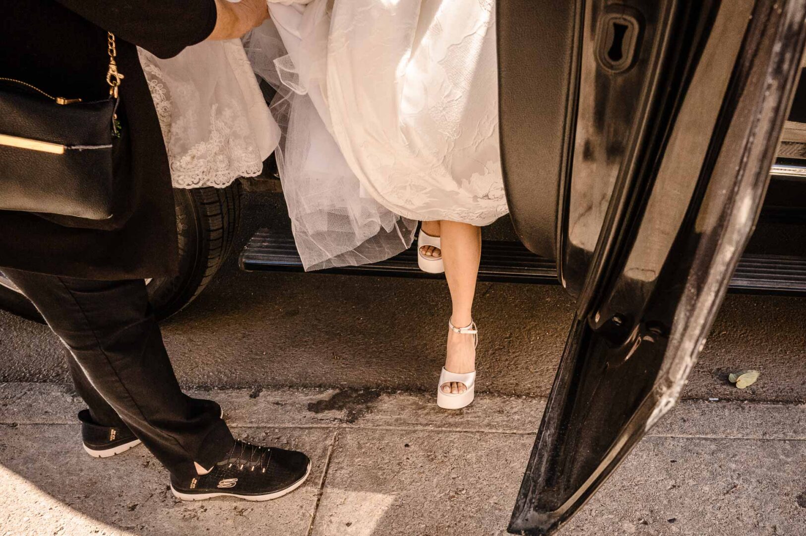 Noreena & Robert's Elegant Wedding at San Fernando Cathedral 12 Bride entering car, wedding attire visible.