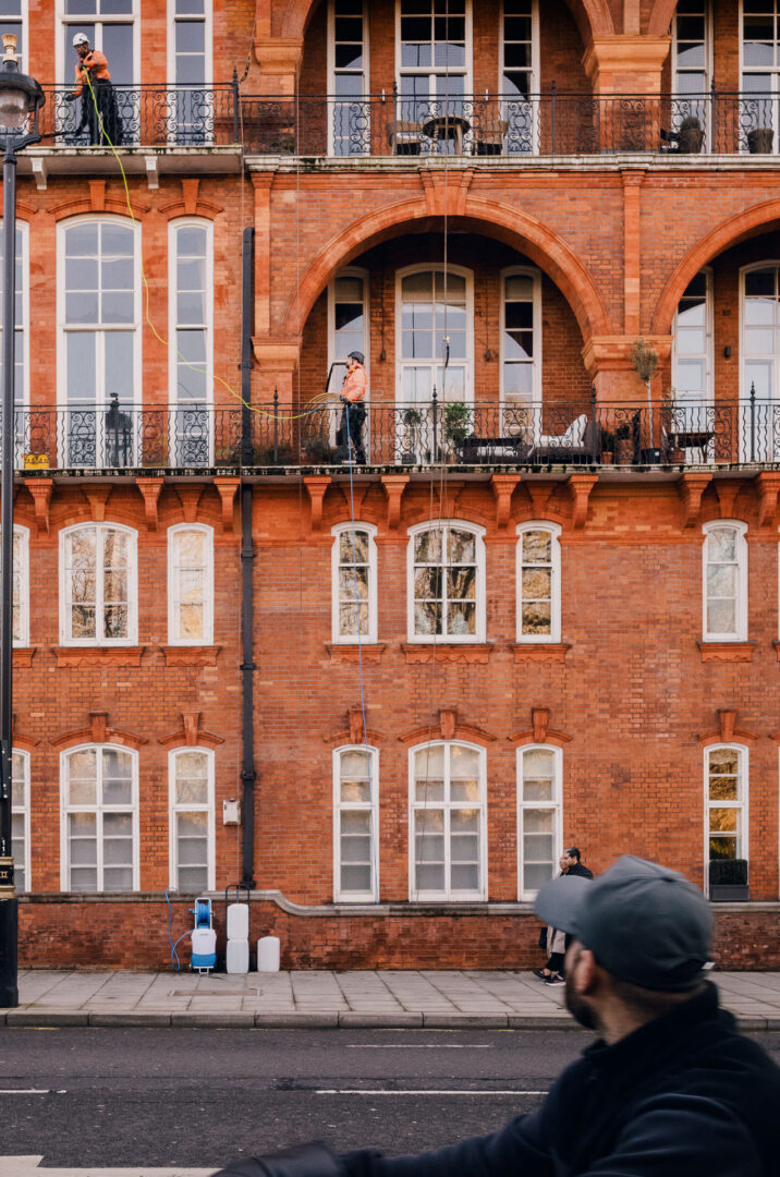 Rain, Reflections & Walking London with a Leica M11 (28mm) 12 People on balcony of brick building.