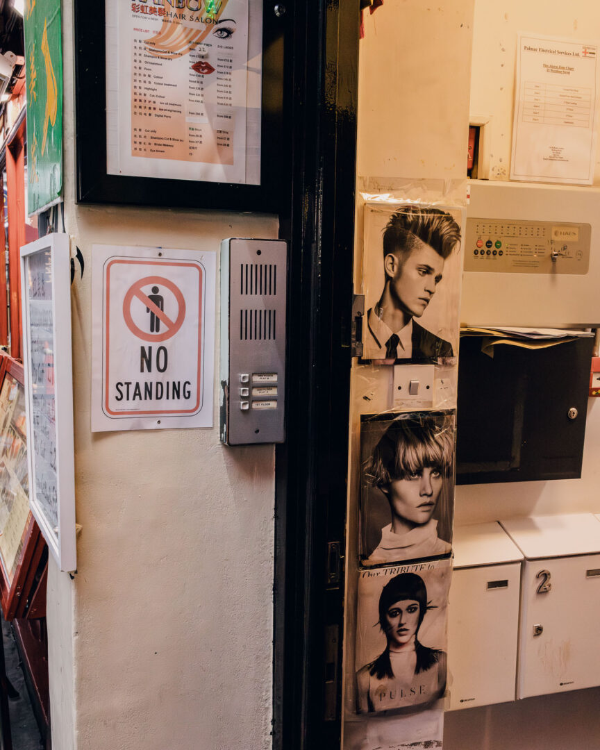 Rain, Reflections & Walking London with a Leica M11 (28mm) 15 A hair salon with stylist photos adorn the entrance to the wall in Chinatown, London