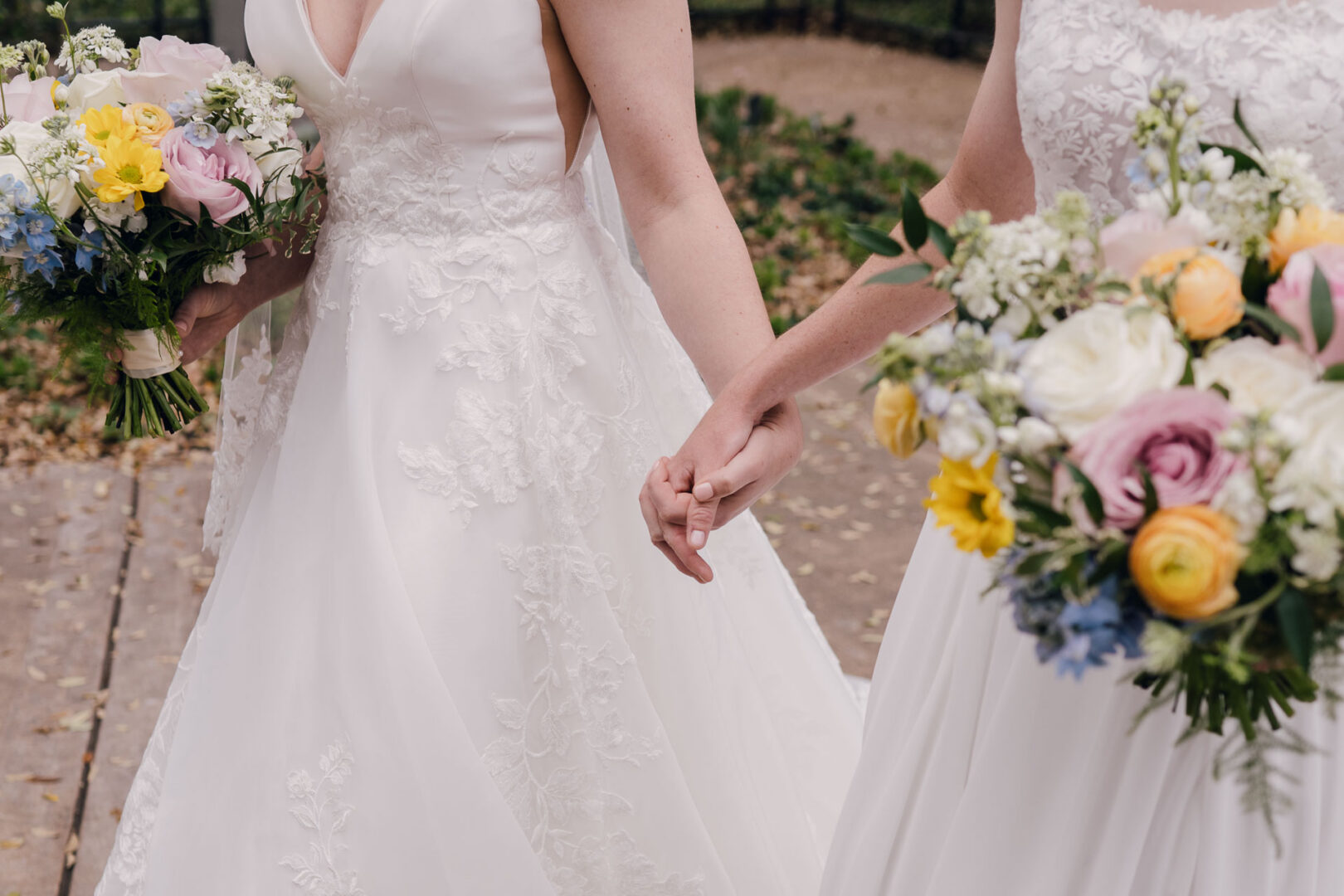 Winter Wedding at Botanical Gardens, San Antonio, Texas 11 Two brides holding hands with bouquets.