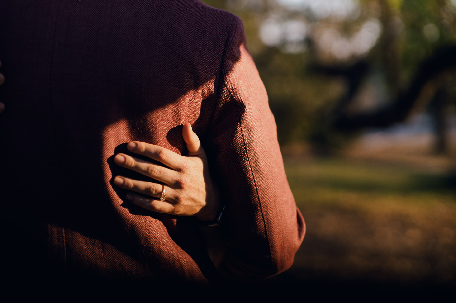 Couple embracing in soft sunlight.