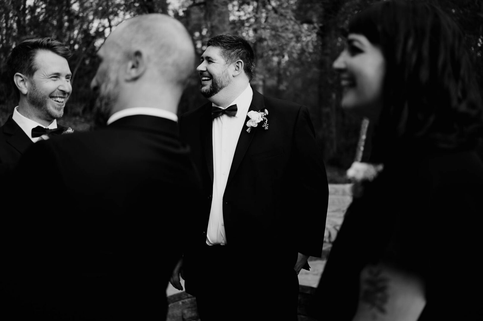 Vibrant Spring Wedding at Shiraz Gardens in Bastrop 15 Black and white candid wedding photo of the groom with groomsmen before the ceremony at Shiraz Gardens.