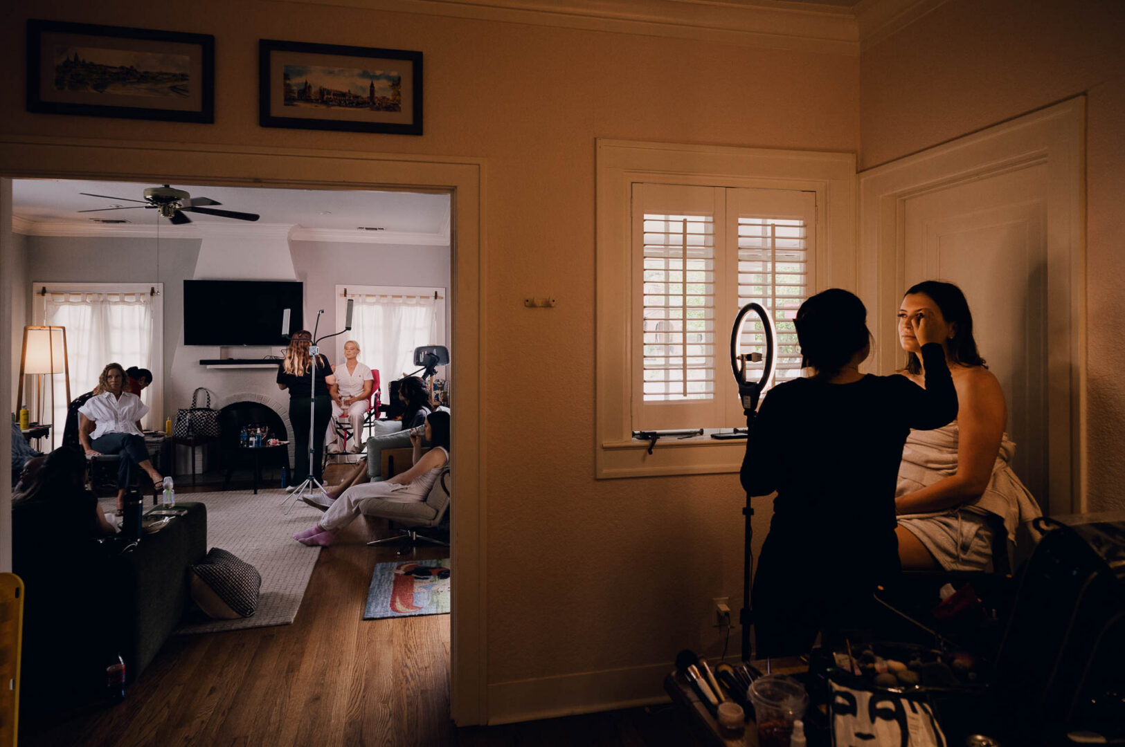 Guests seen through an open doorway during indoor wedding preparations.