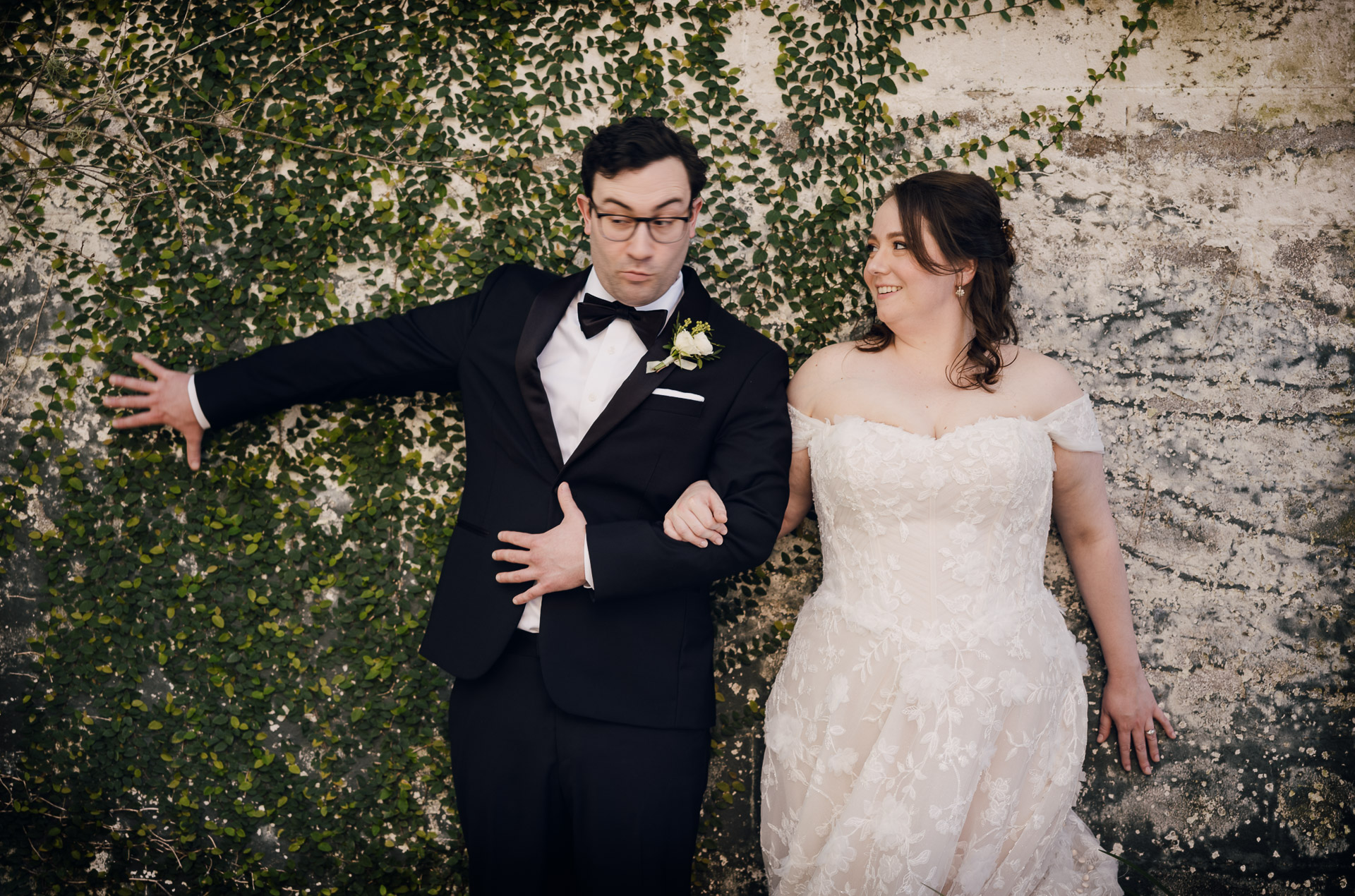 Oak Tree Ceremony & Candlelit Reception at The Houstonian 12 In a comical moment, Bride and groom walking arm in arm outdoors at The Houstonian Hotel in Houston.