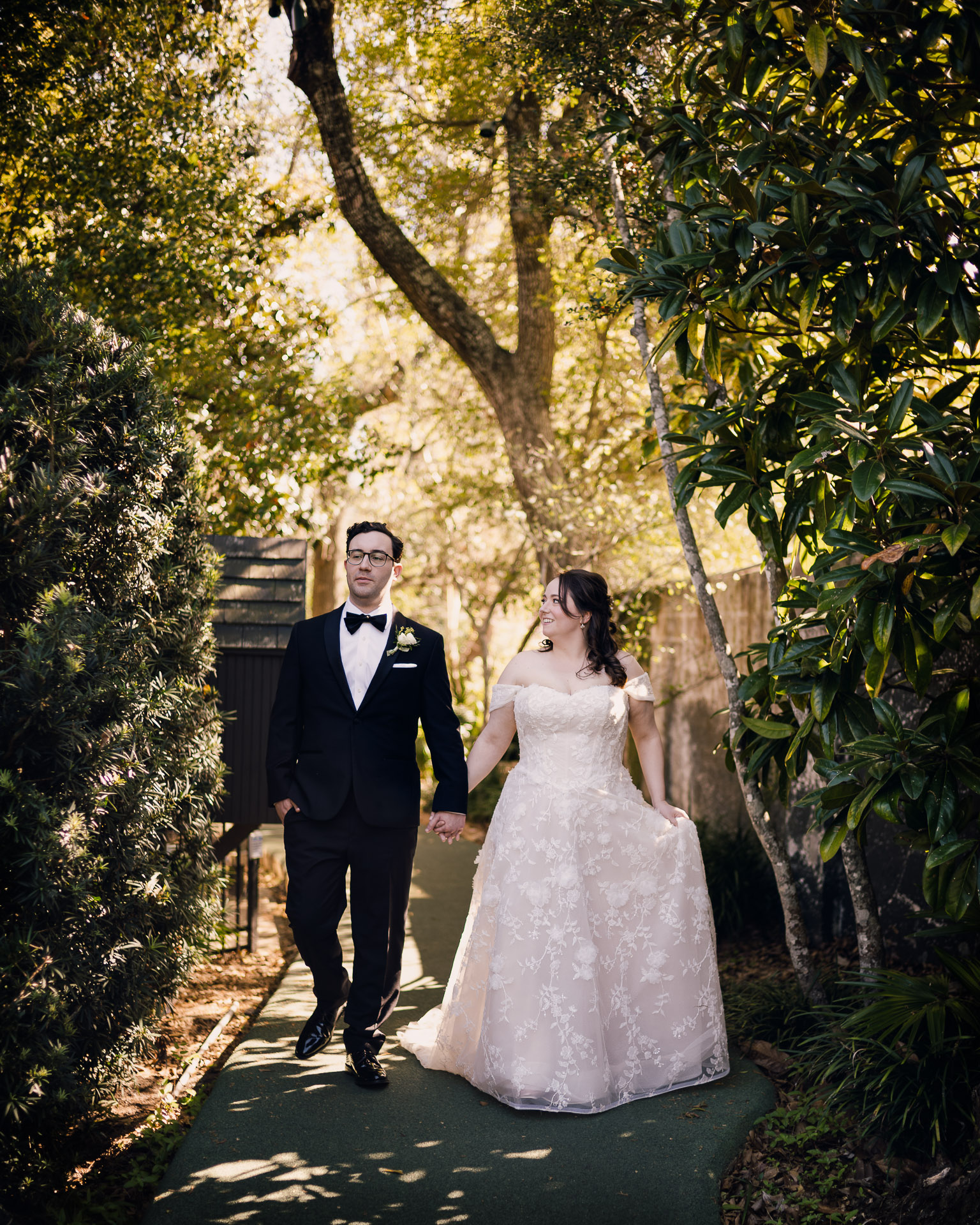 Oak Tree Ceremony & Candlelit Reception at The Houstonian 34 Bride and groom standing together on a tree-lined path at The Houstonian Hotel.