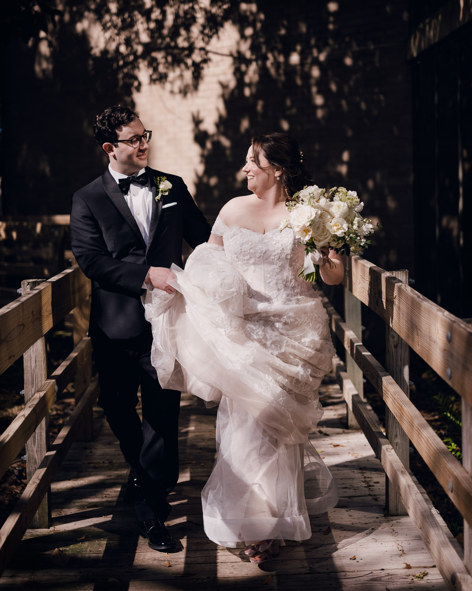 Oak Tree Ceremony & Candlelit Reception at The Houstonian 14 Bride and groom walking across a wooden bridge at The Houstonian Hotel.