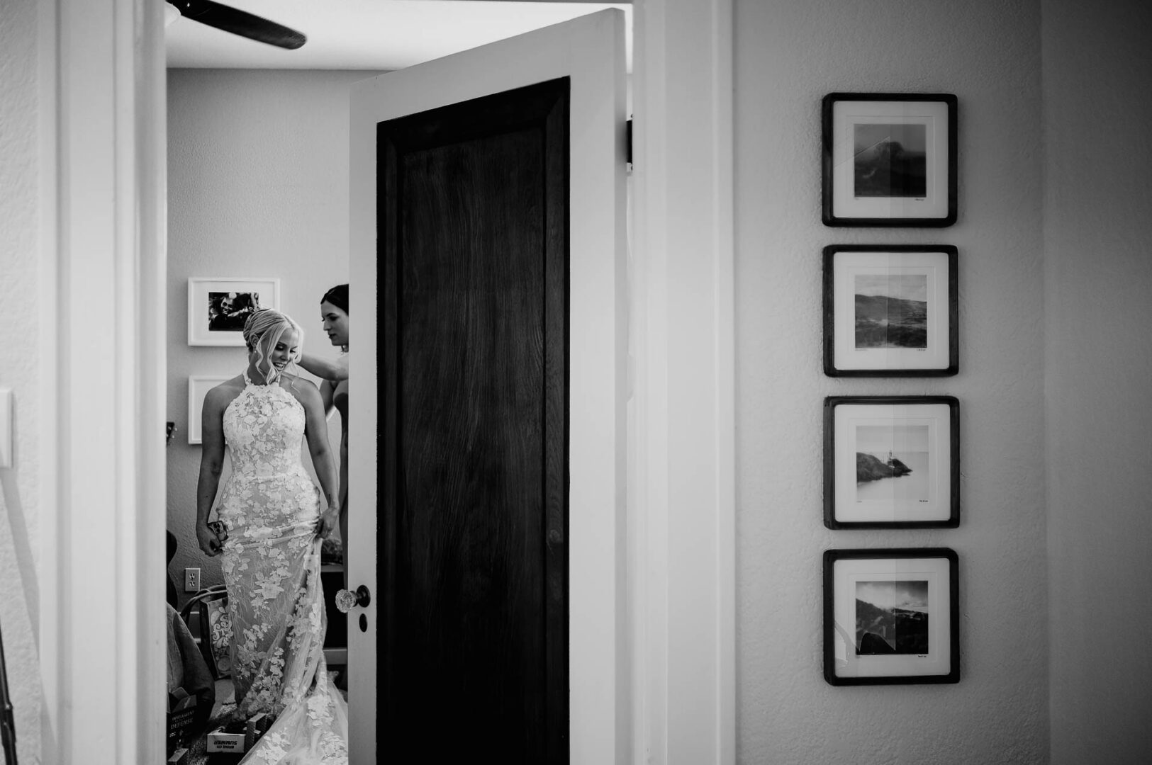 Bride seen through a doorway during quiet indoor wedding preparations.