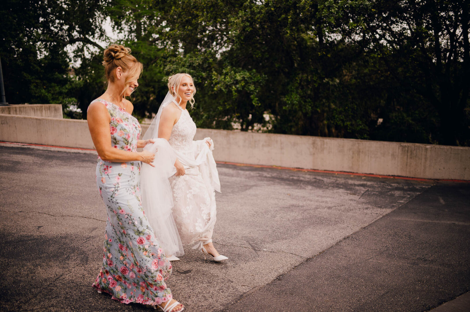 Bride walking with an older guest during a candid outdoor wedding moment.