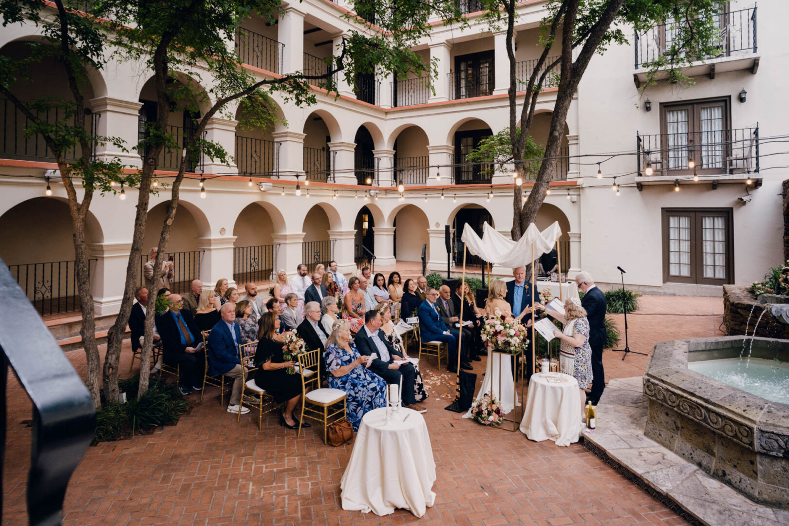 Wide view of wedding ceremony setup and guests in The Courtyard at Omni La Mansión del Rio