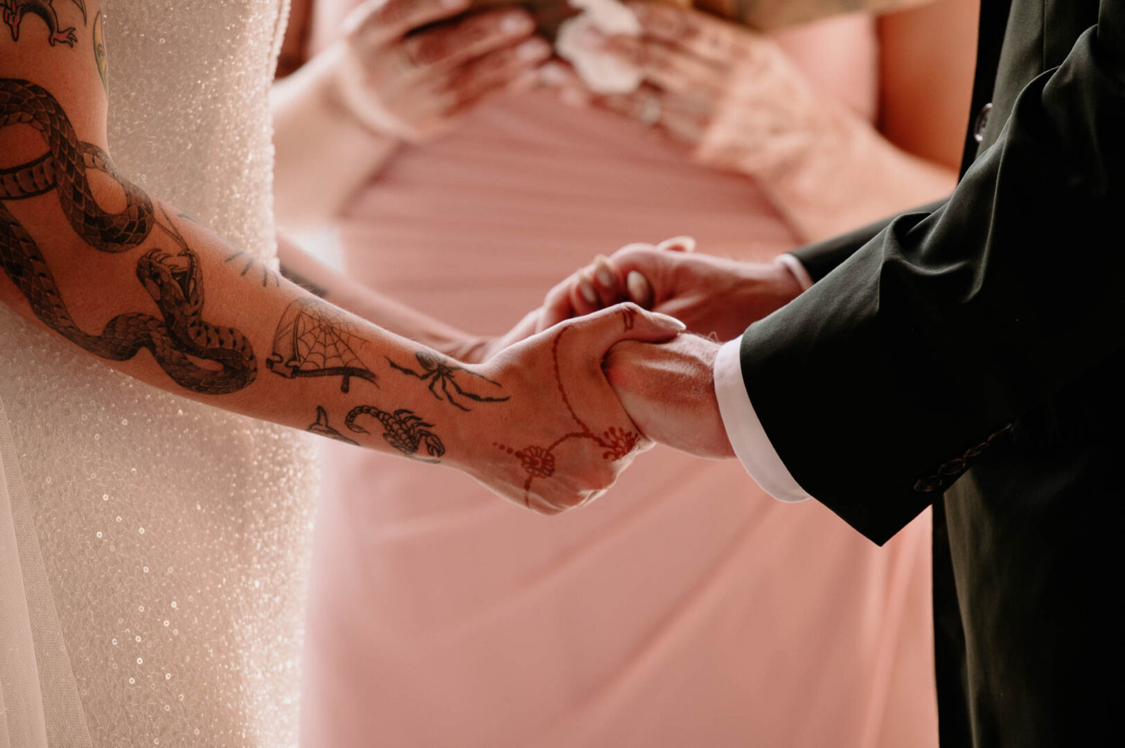 Vibrant Spring Wedding at Shiraz Gardens in Bastrop 33 Close-up wedding detail of the bride and groom holding hands during their ceremony at Shiraz Gardens.