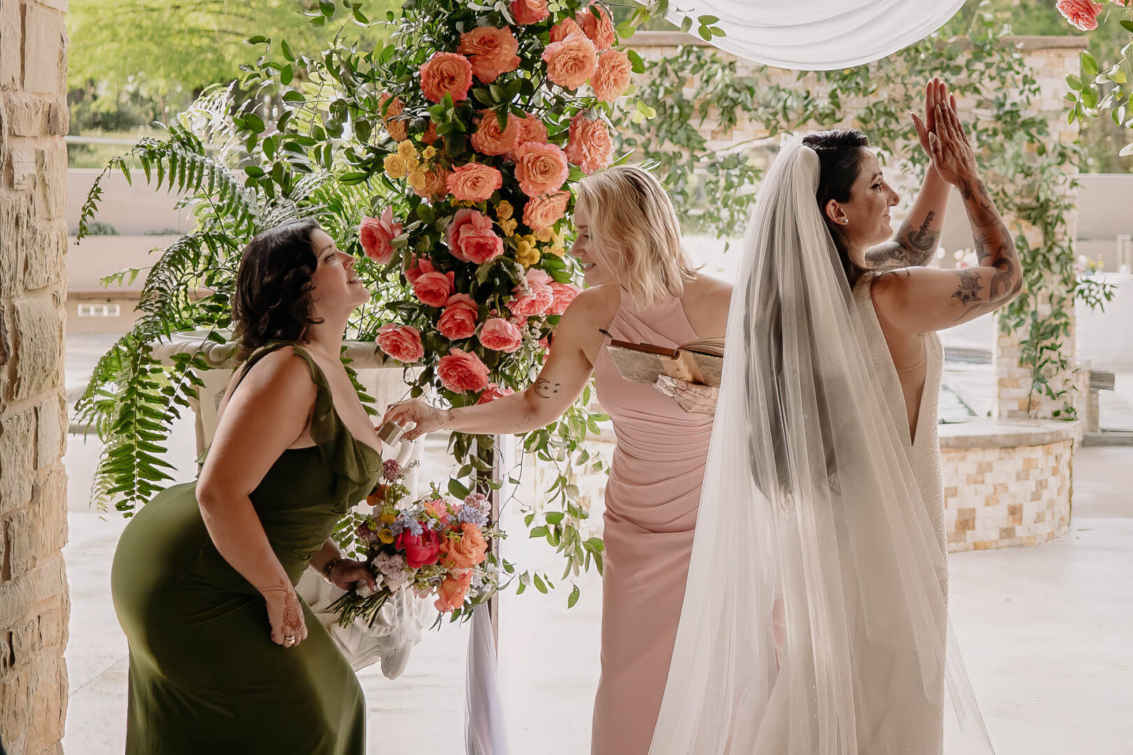 Vibrant Spring Wedding at Shiraz Gardens in Bastrop 34 Documentary wedding photograph of the bride standing beneath the floral ceremony arch at Shiraz Gardens.