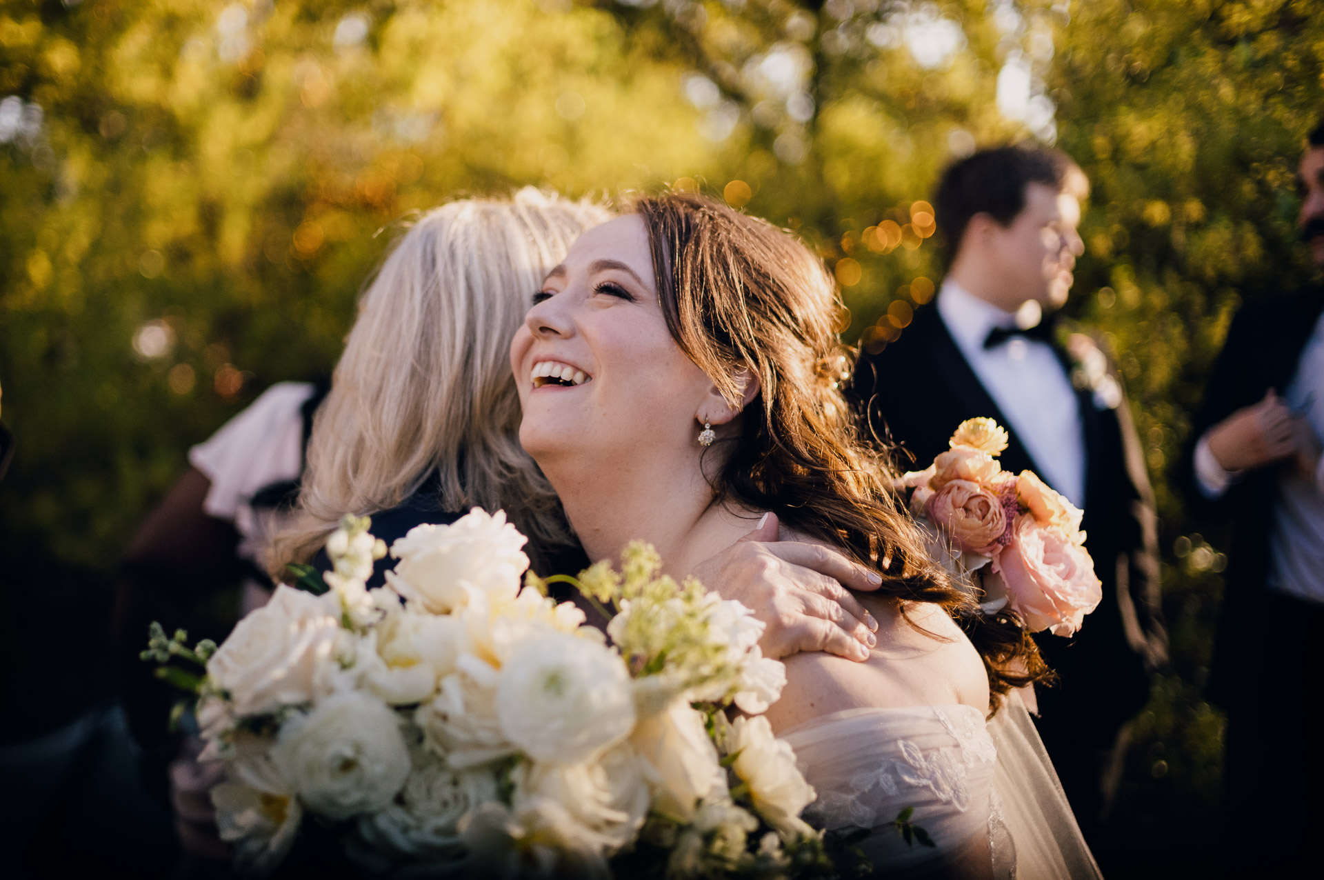 Oak Tree Ceremony & Candlelit Reception at The Houstonian 31 Bride laughing with her bouquet during an outdoor portrait at The Houstonian Hotel.
