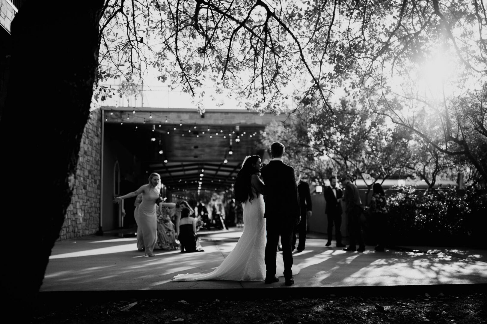Vibrant Spring Wedding at Shiraz Gardens in Bastrop 41 Black and white documentary wedding portrait of the bride and groom beneath trees at Shiraz Gardens.