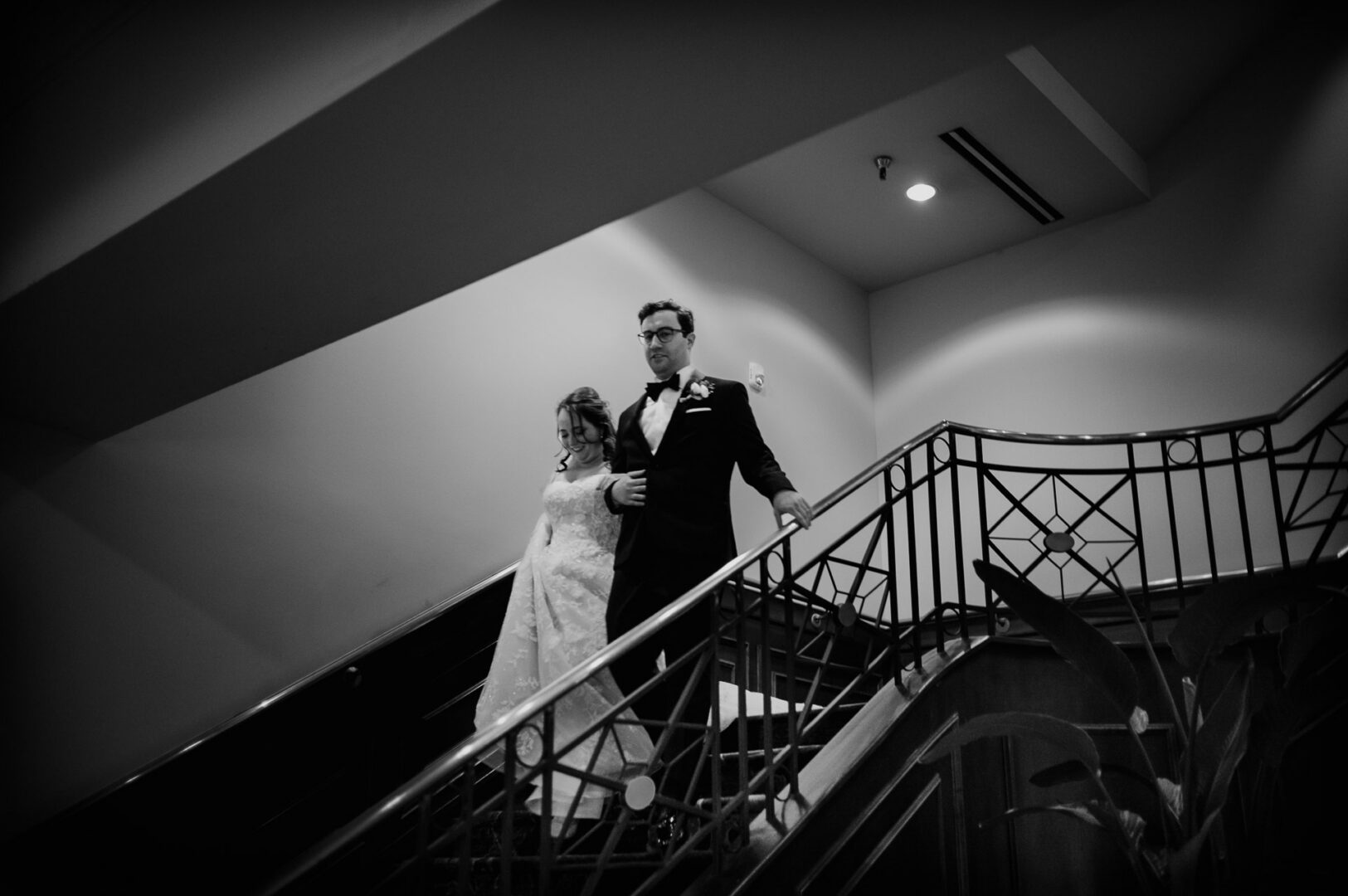 Bride and groom descending a staircase at The Houstonian Hotel in Houston.