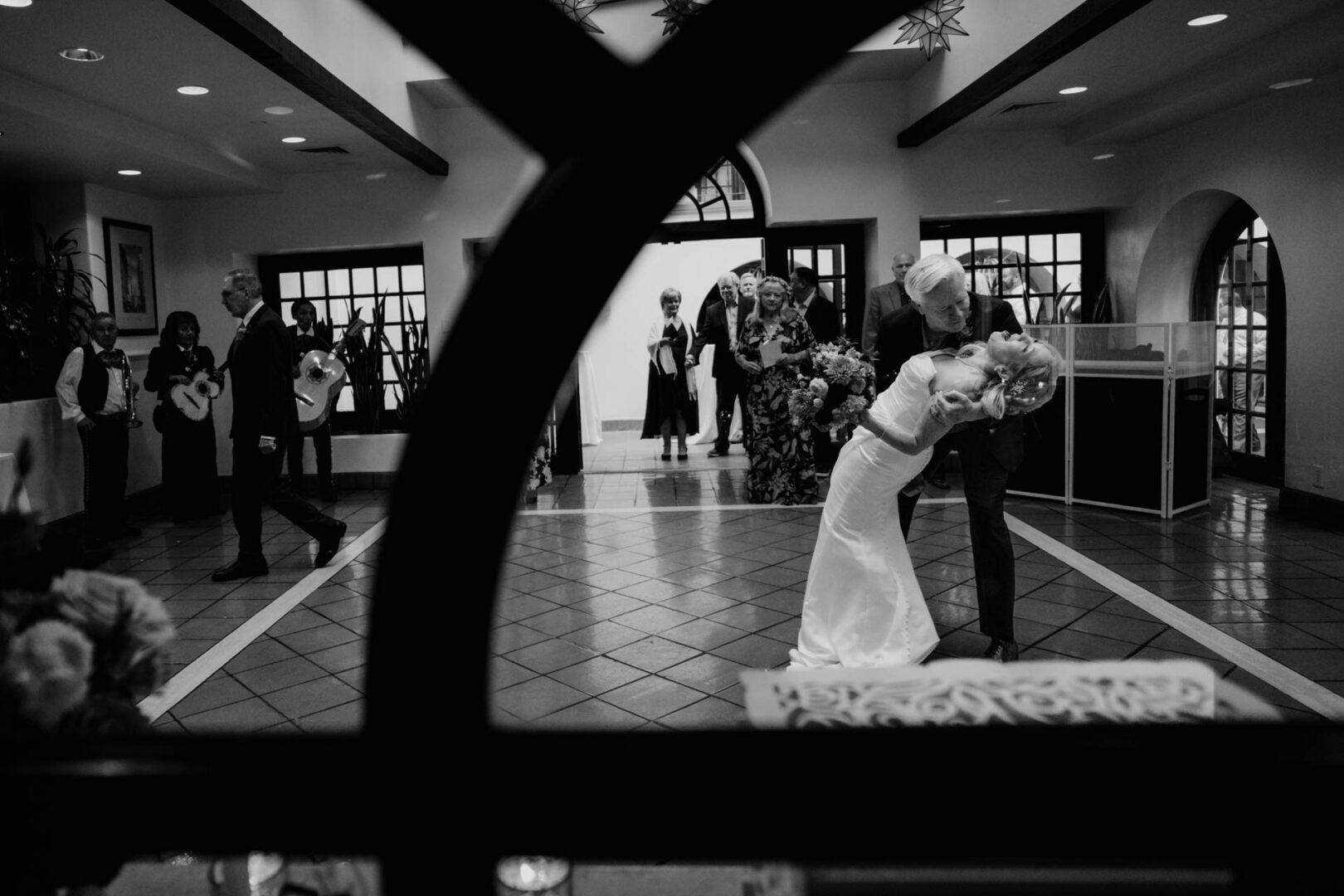 Black and white first dance photographed through architectural framing at Omni La Mansión del Rio