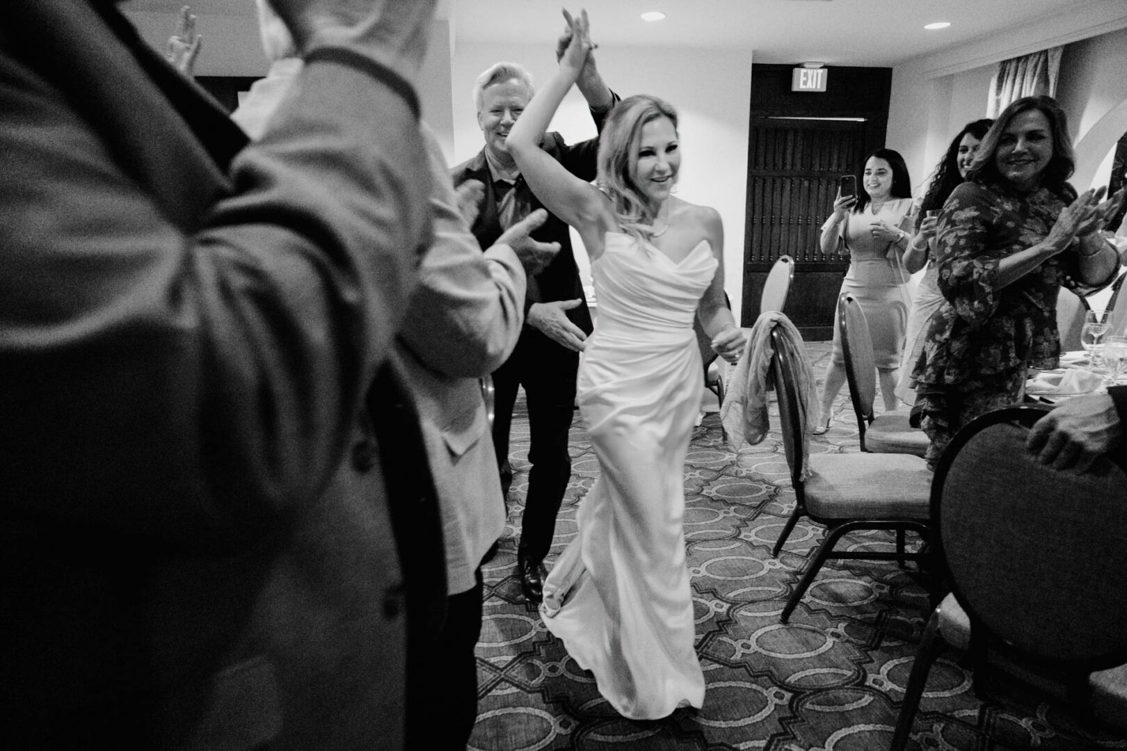 Black and white candid of bride dancing with guests at Omni La Mansión del Rio reception