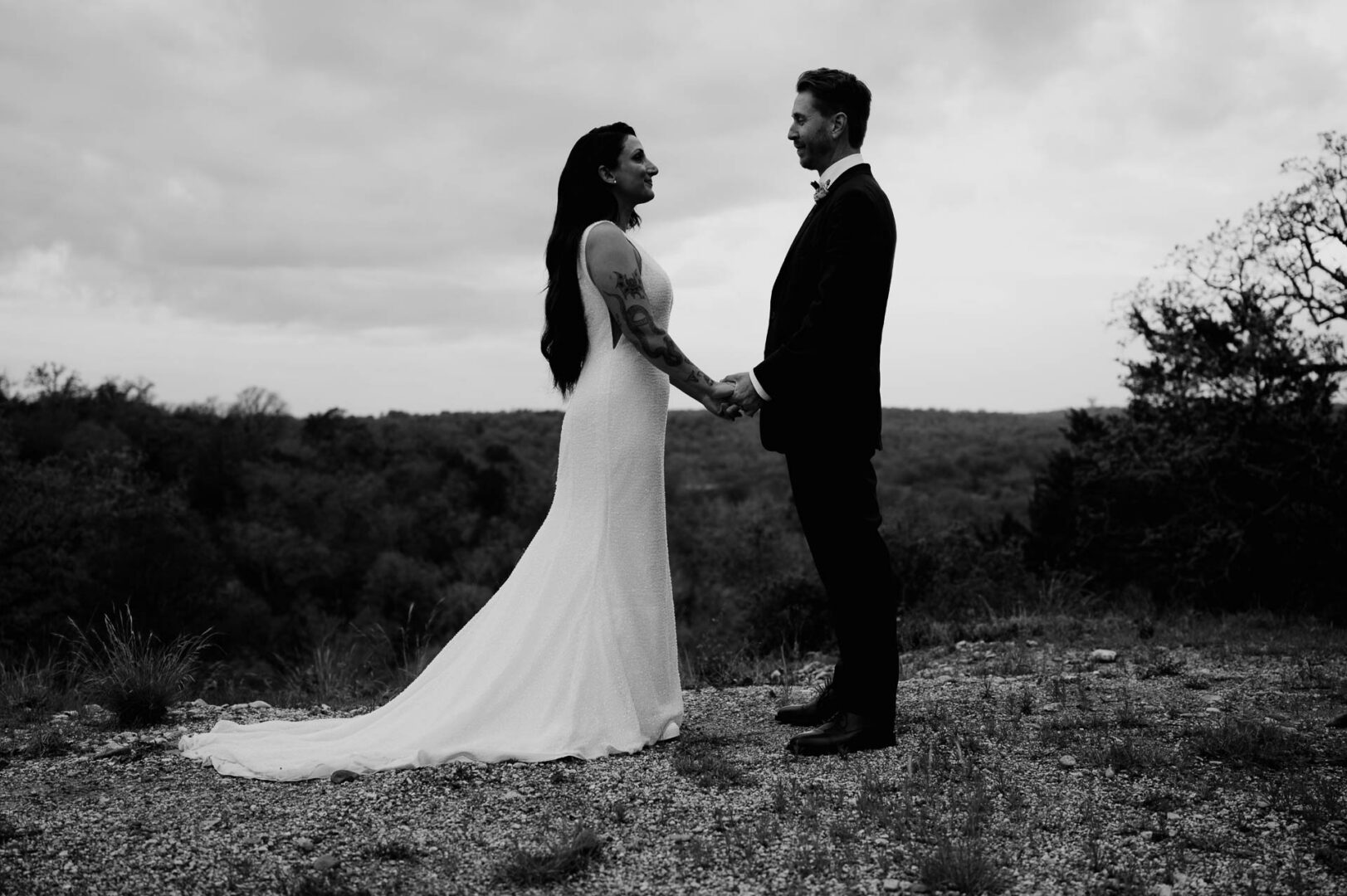 Vibrant Spring Wedding at Shiraz Gardens in Bastrop 57 Black and white wedding portrait of the bride and groom standing together in the open landscape at Shiraz Gardens in Bastrop, Texas.