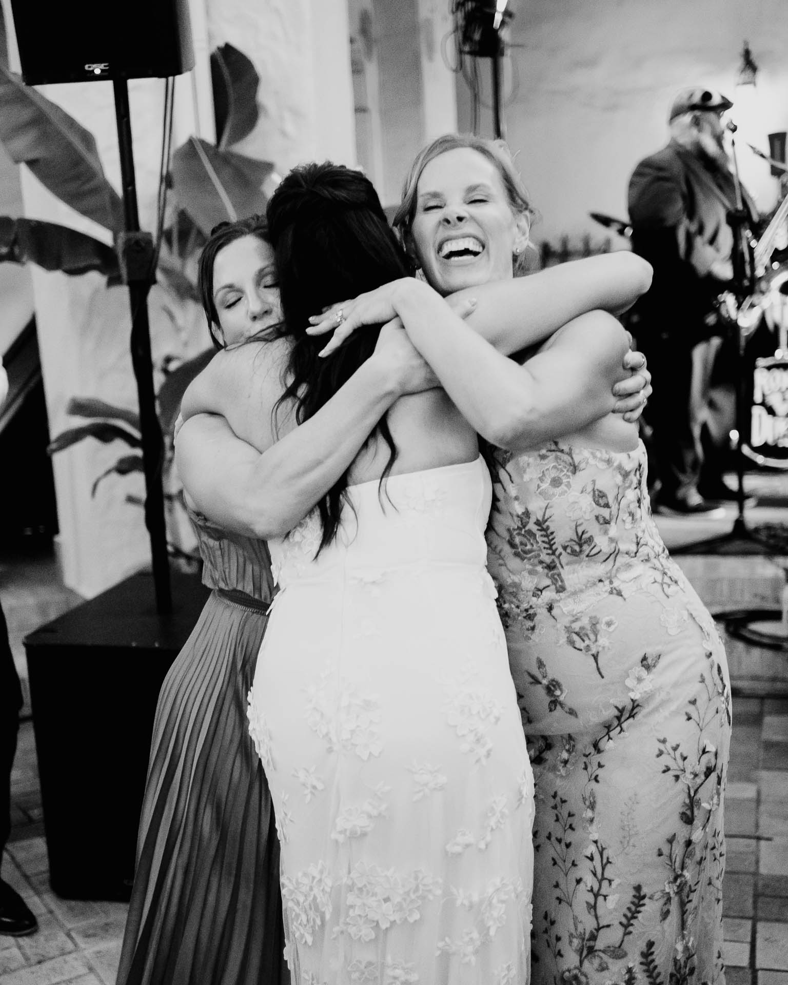 Documentary Wedding Portfolio | Philip Thomas 209 Black and white candid photo of wedding guests hugging during the reception.