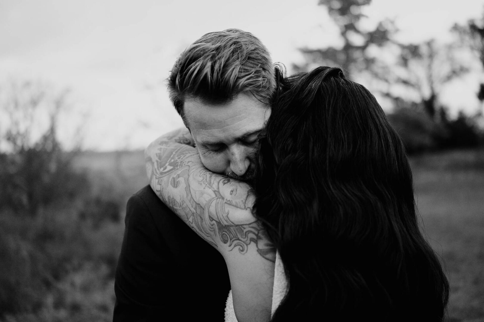 Vibrant Spring Wedding at Shiraz Gardens in Bastrop 60 Black and white close-up wedding portrait of the groom kissing the bride at Shiraz Gardens in Bastrop, Texas.