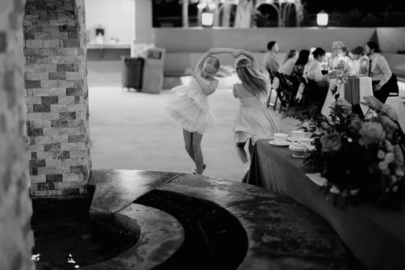 Vibrant Spring Wedding at Shiraz Gardens in Bastrop 63 Black and white candid wedding photo of the bride walking past guests during the reception at Shiraz Gardens in Bastrop, Texas.