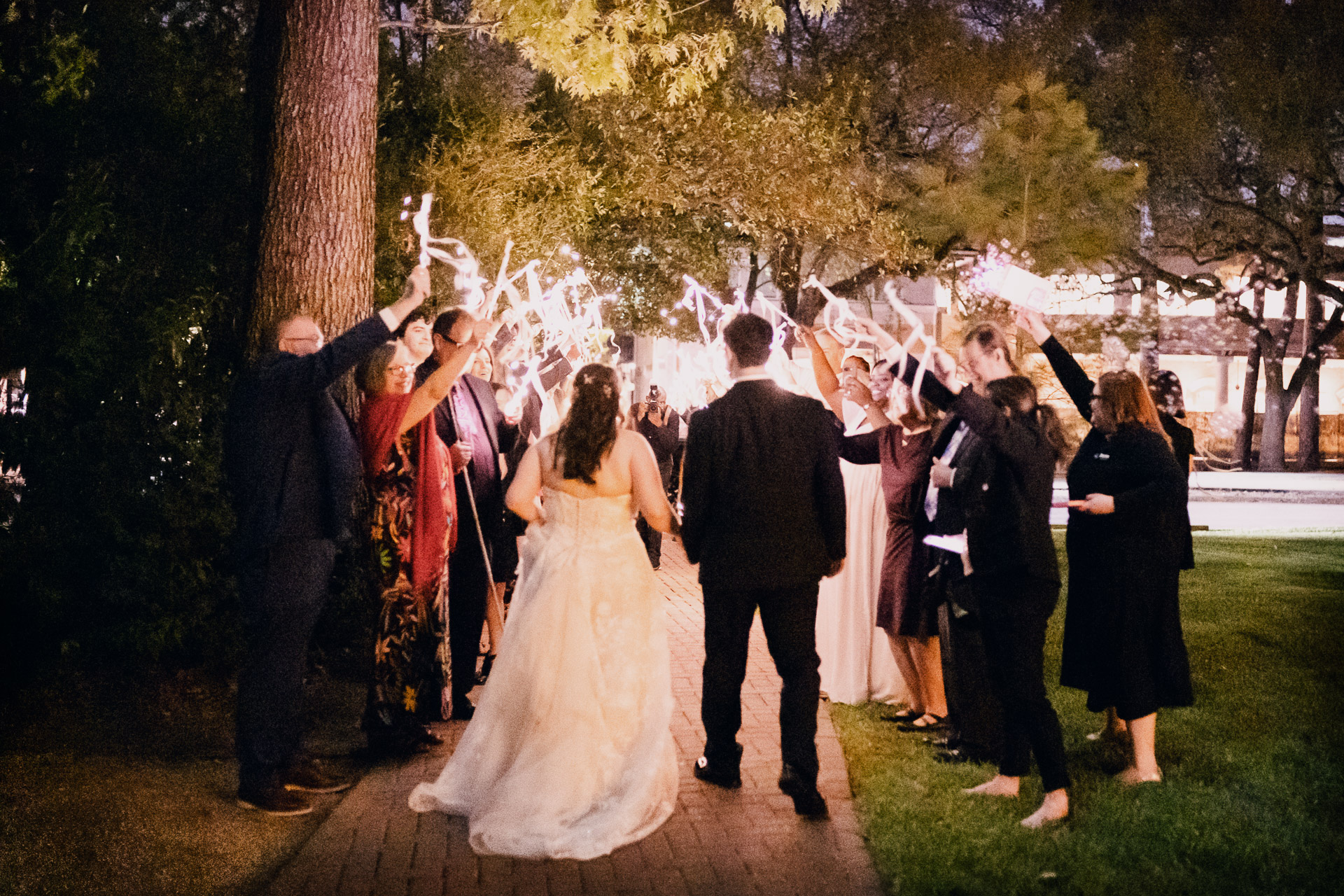Oak Tree Ceremony & Candlelit Reception at The Houstonian 55 Houstonian Hotel Couple celebrating with sparklers at night.