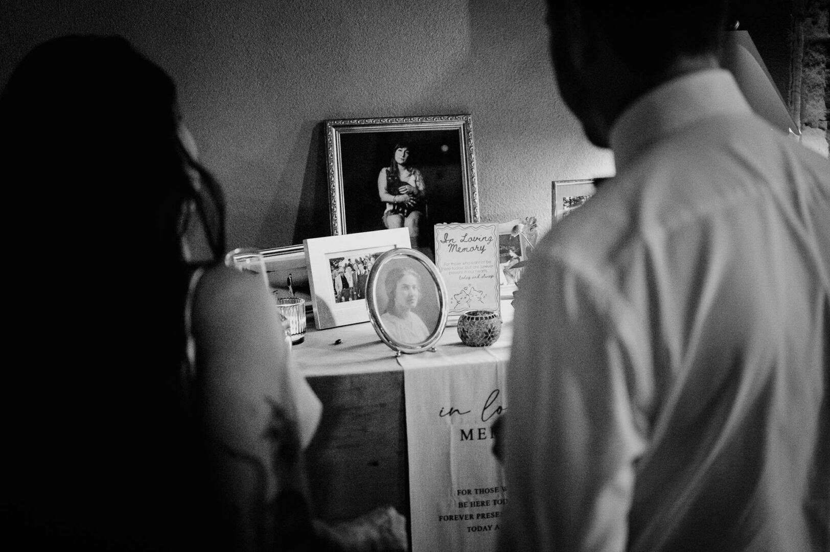 Vibrant Spring Wedding at Shiraz Gardens in Bastrop 78 Black and white documentary wedding photo of guests watching a screen during the reception at Shiraz Gardens in Bastrop, Texas.