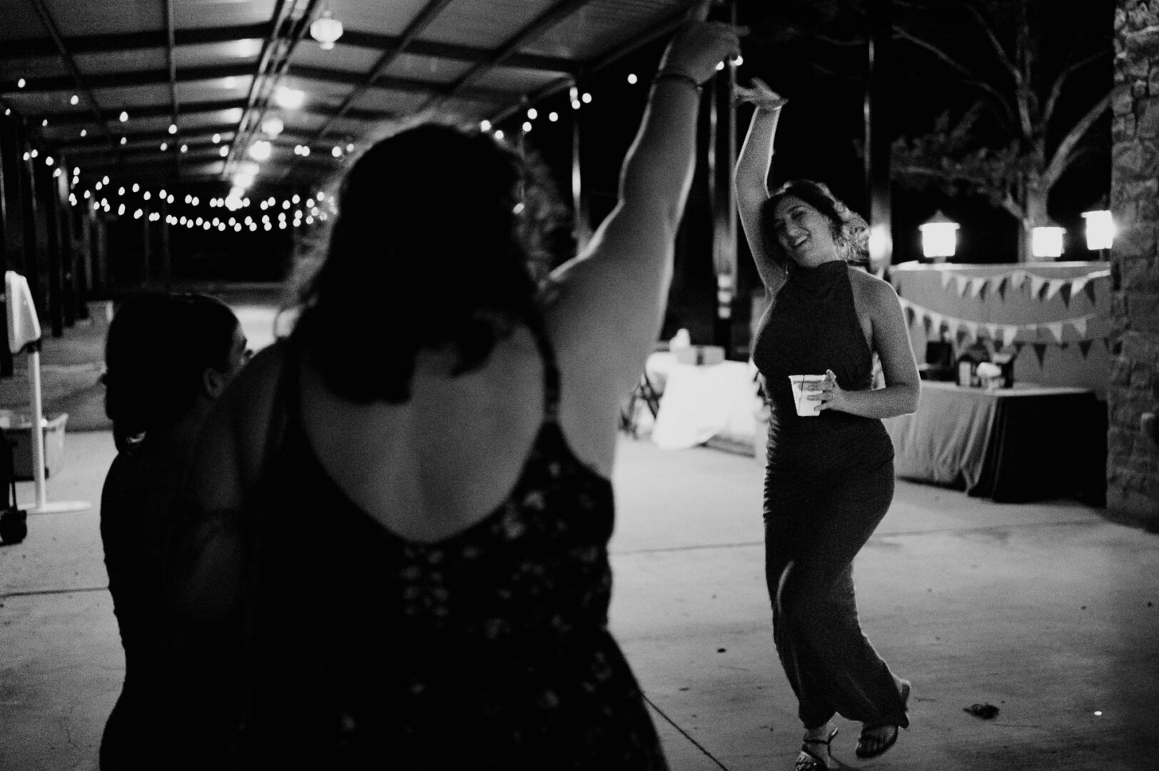 Vibrant Spring Wedding at Shiraz Gardens in Bastrop 84 Black and white documentary wedding photo of guests dancing during the reception at Shiraz Gardens in Bastrop, Texas.