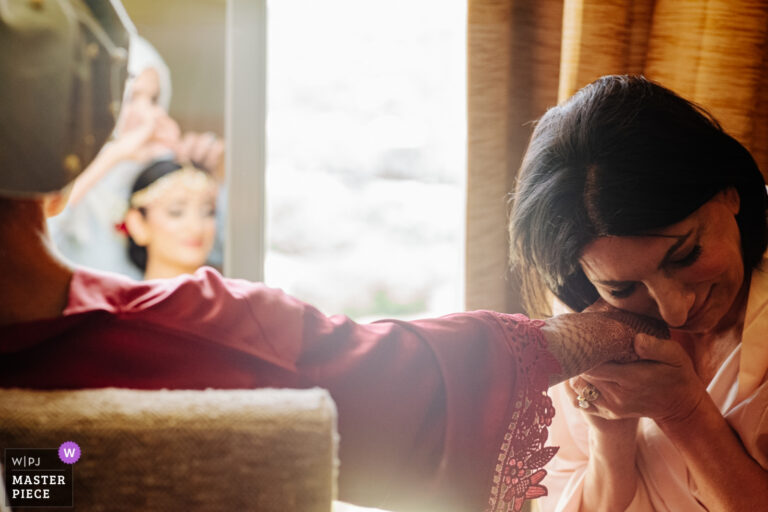 Mother of the bride kisses her hand in a fleeting moments