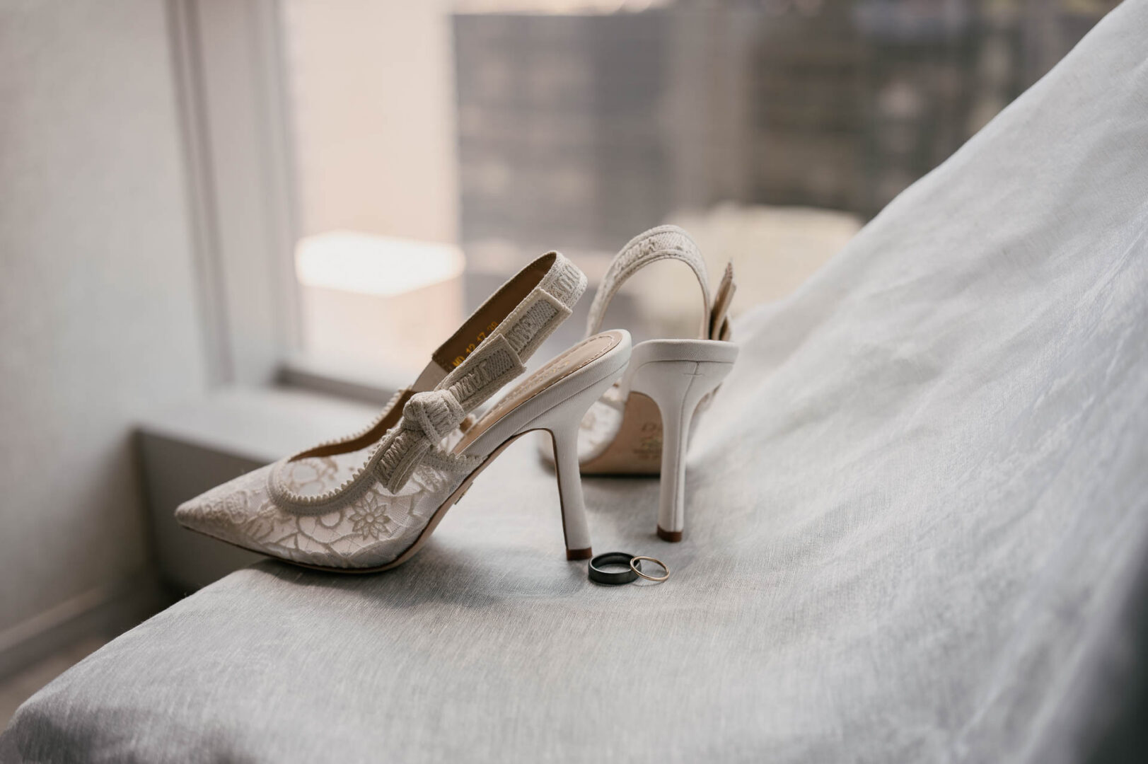Bridal shoes and wedding details photographed in soft hotel room light.