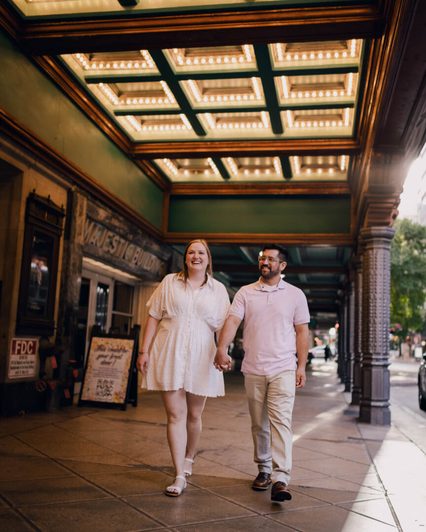 Couple walking under theater marquee lights.
