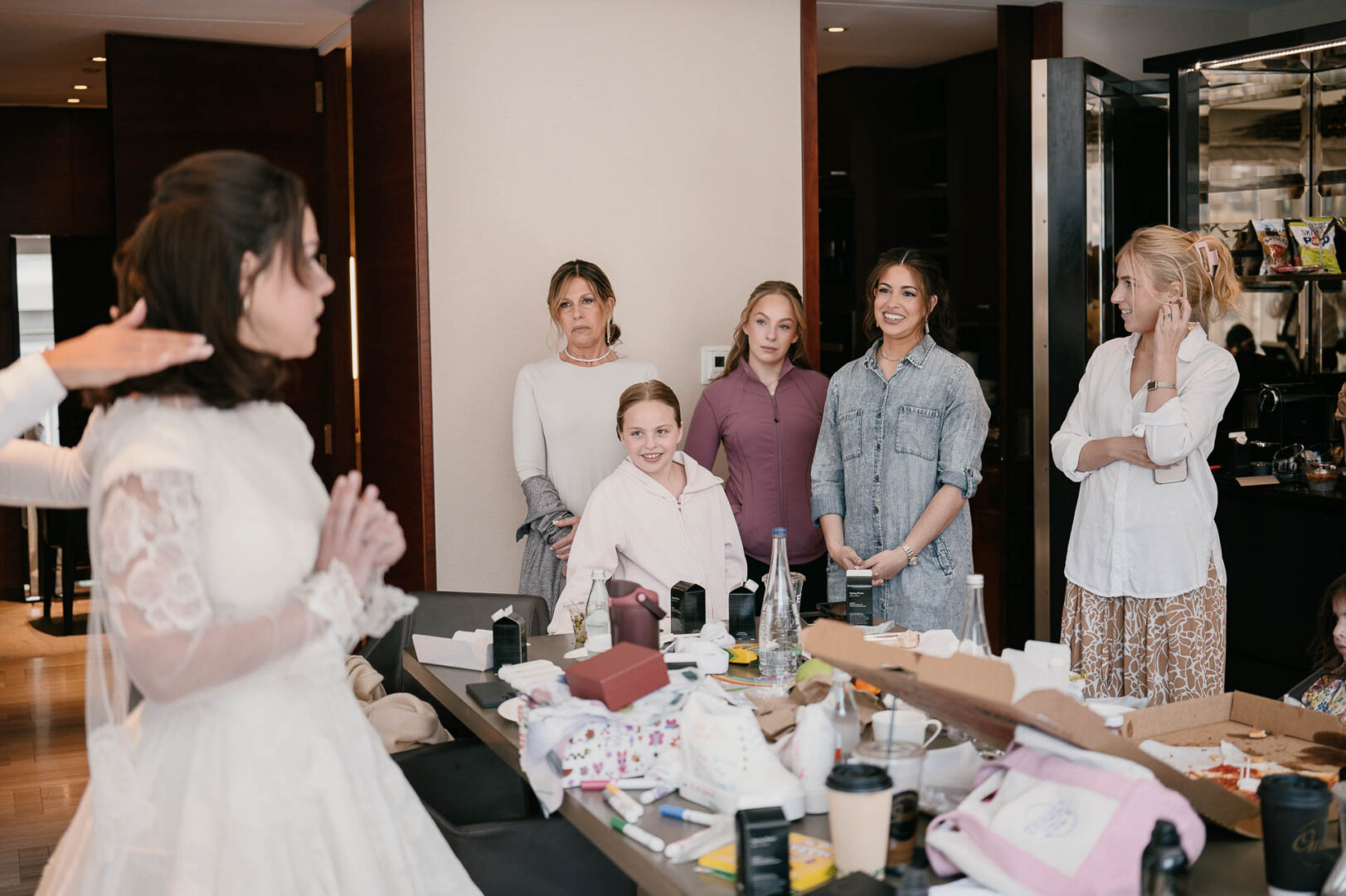 Bride with family and attendants in the hotel room before the ceremony.
