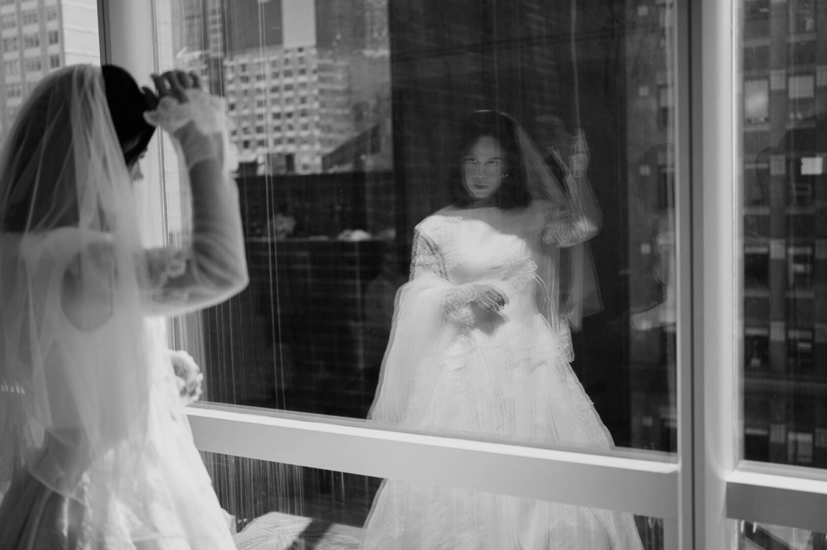 Black and white reflection of the bride in her hotel room before the wedding.