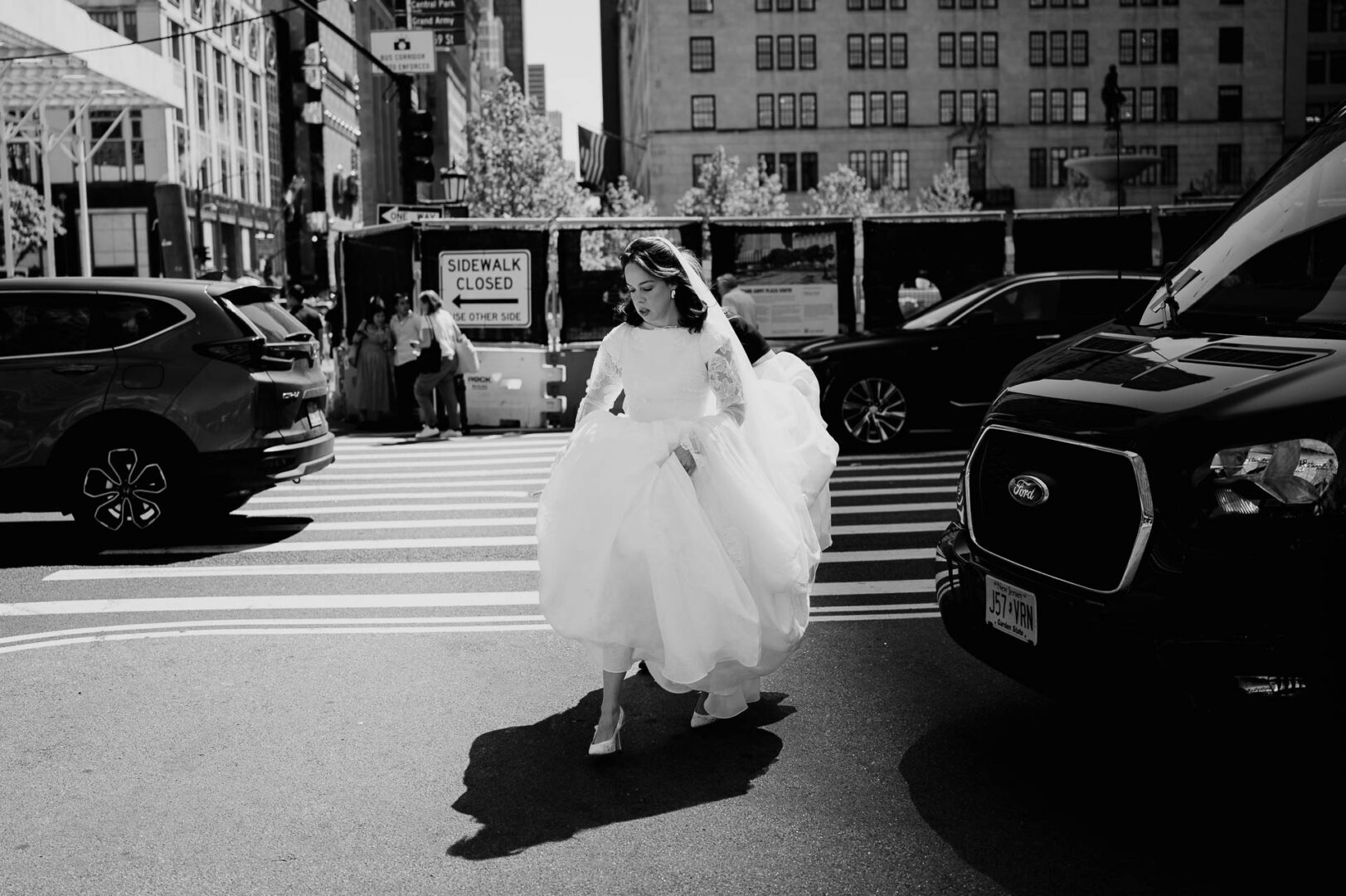 Black and white street photograph of the bride walking in New York City.