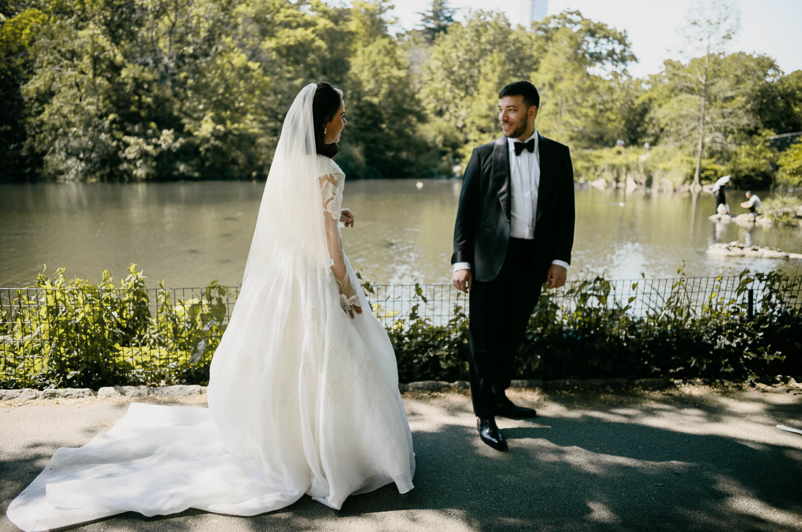 Bride and groom standing by the water in Central Park after their first look.