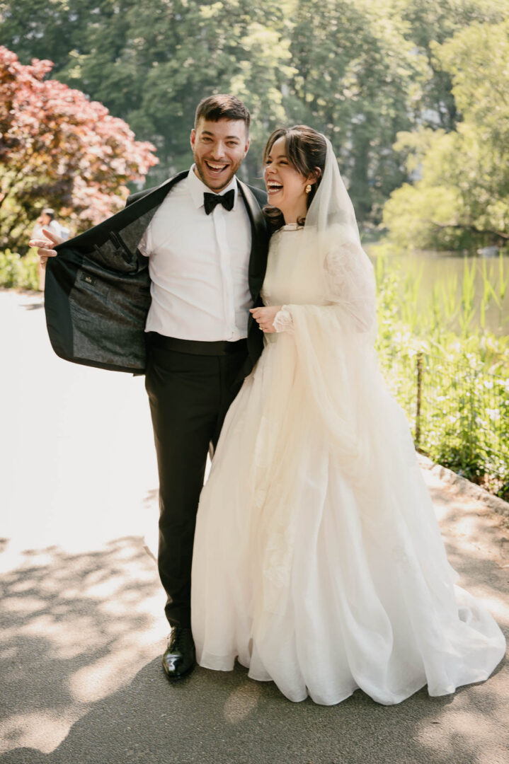 Groom helping the bride with her dress during portraits in Central Park.