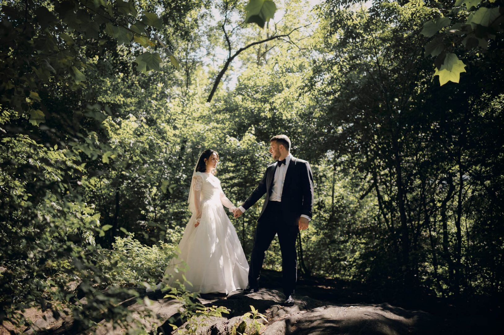 Bride and groom standing together in spring light in Central Park.