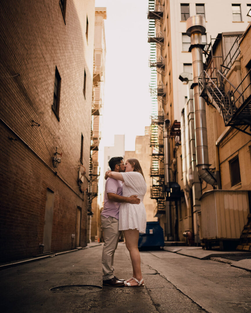 Couple embracing in urban alleyway.