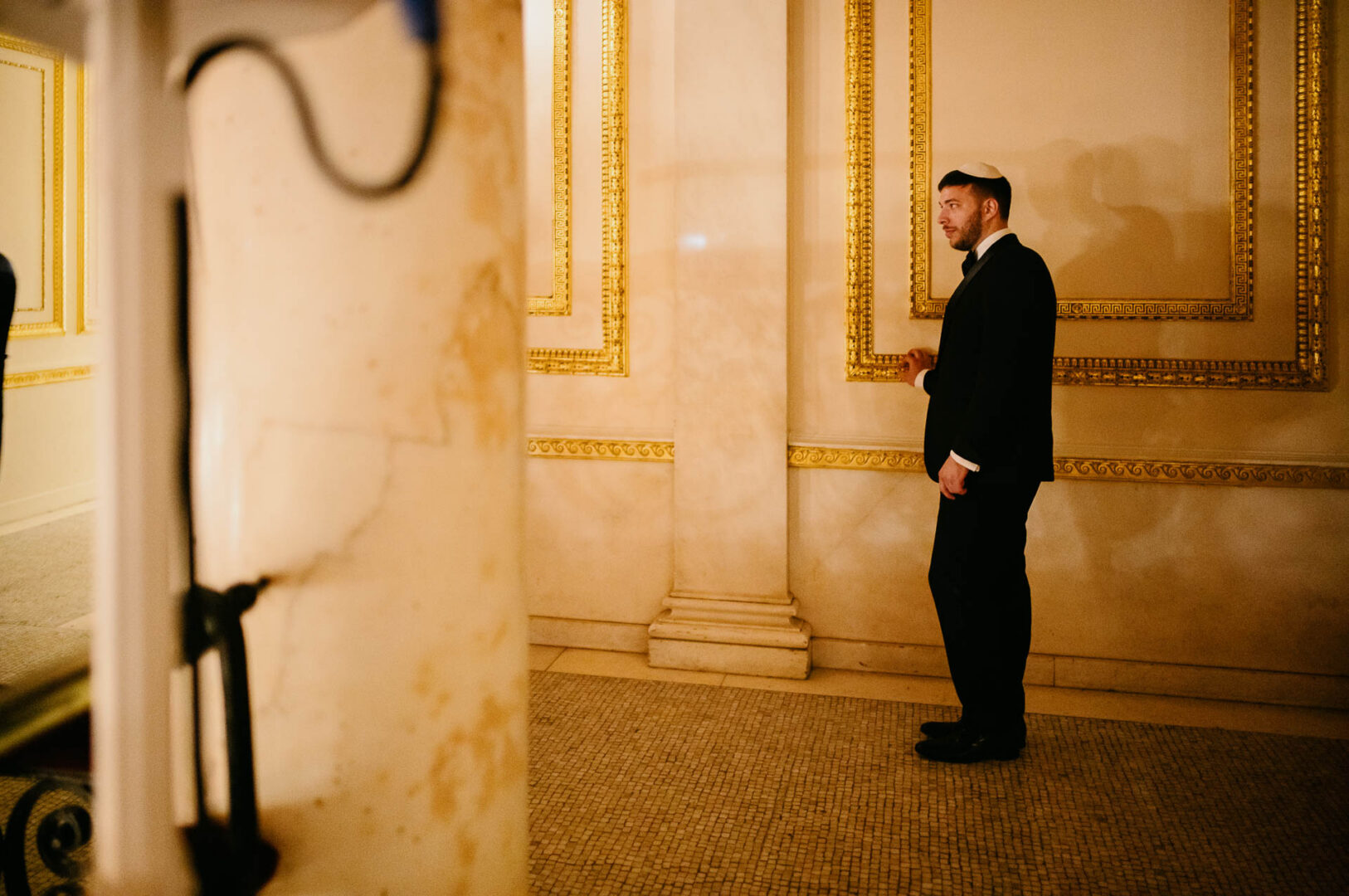 Groom standing quietly in a hallway before the Orthodox Jewish ceremony.