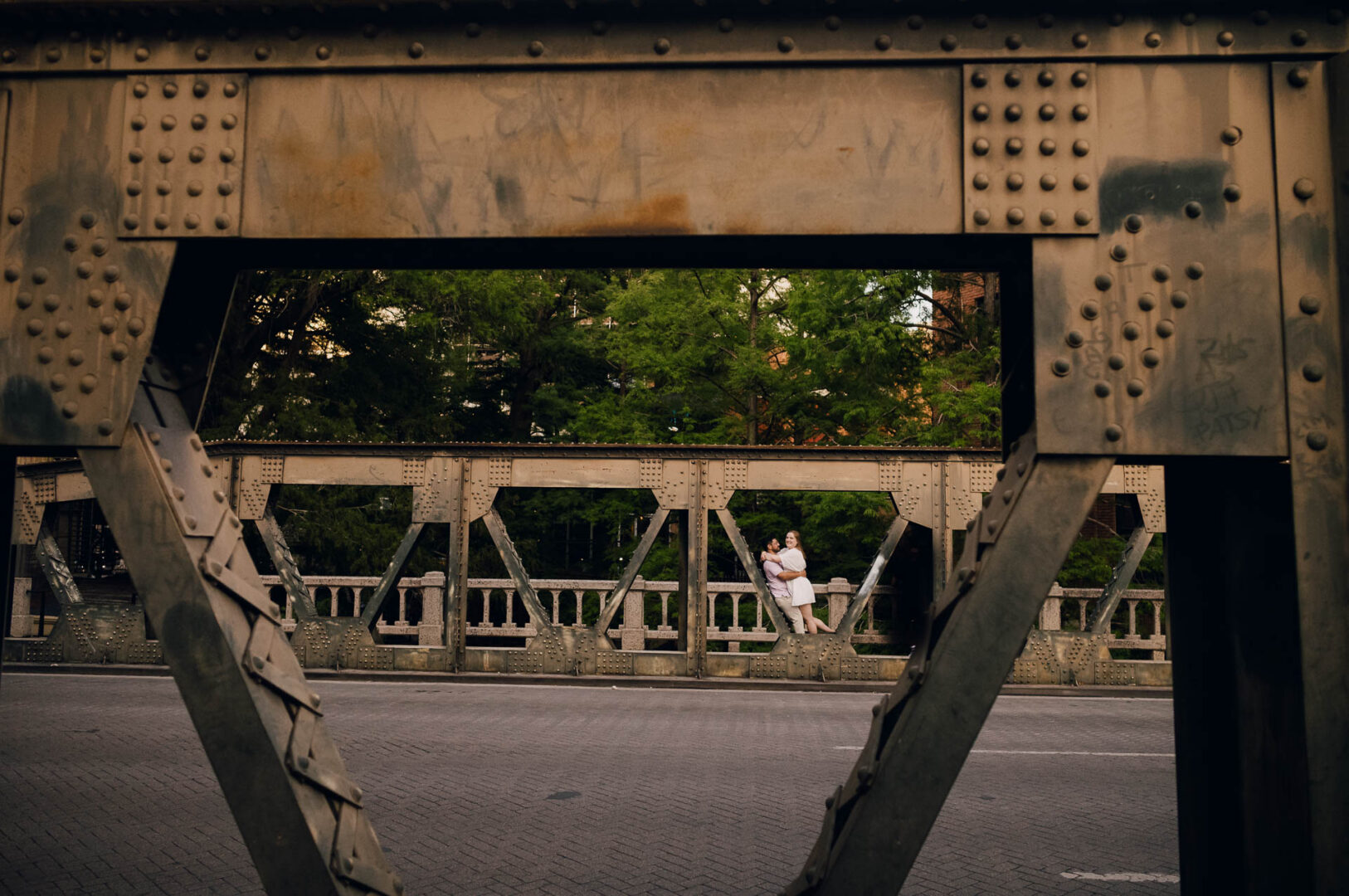 Couple embracing on a bridge.