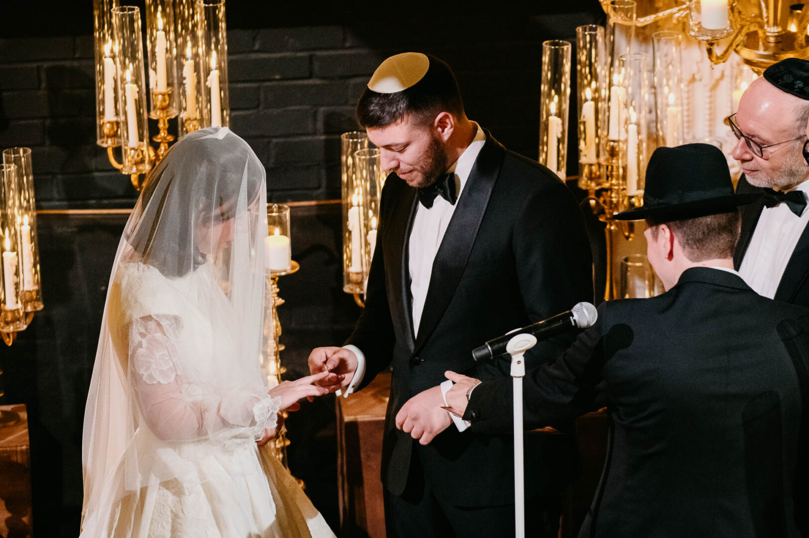 Groom photographed beneath the chuppah during the wedding ceremony.